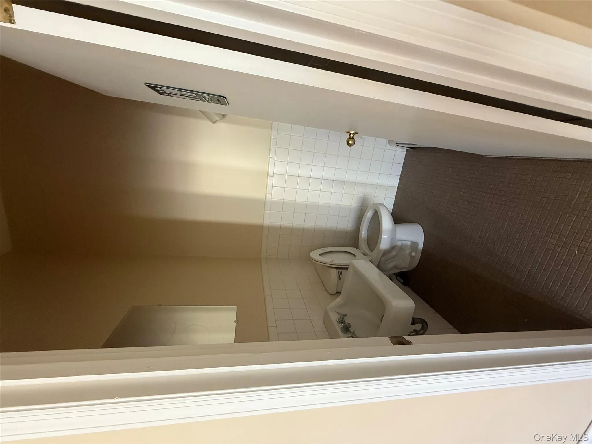 Half bath with tile walls, wainscoting, and dark tile patterned floors Half bath with tile walls, wainscoting, and dark tile patterned floors