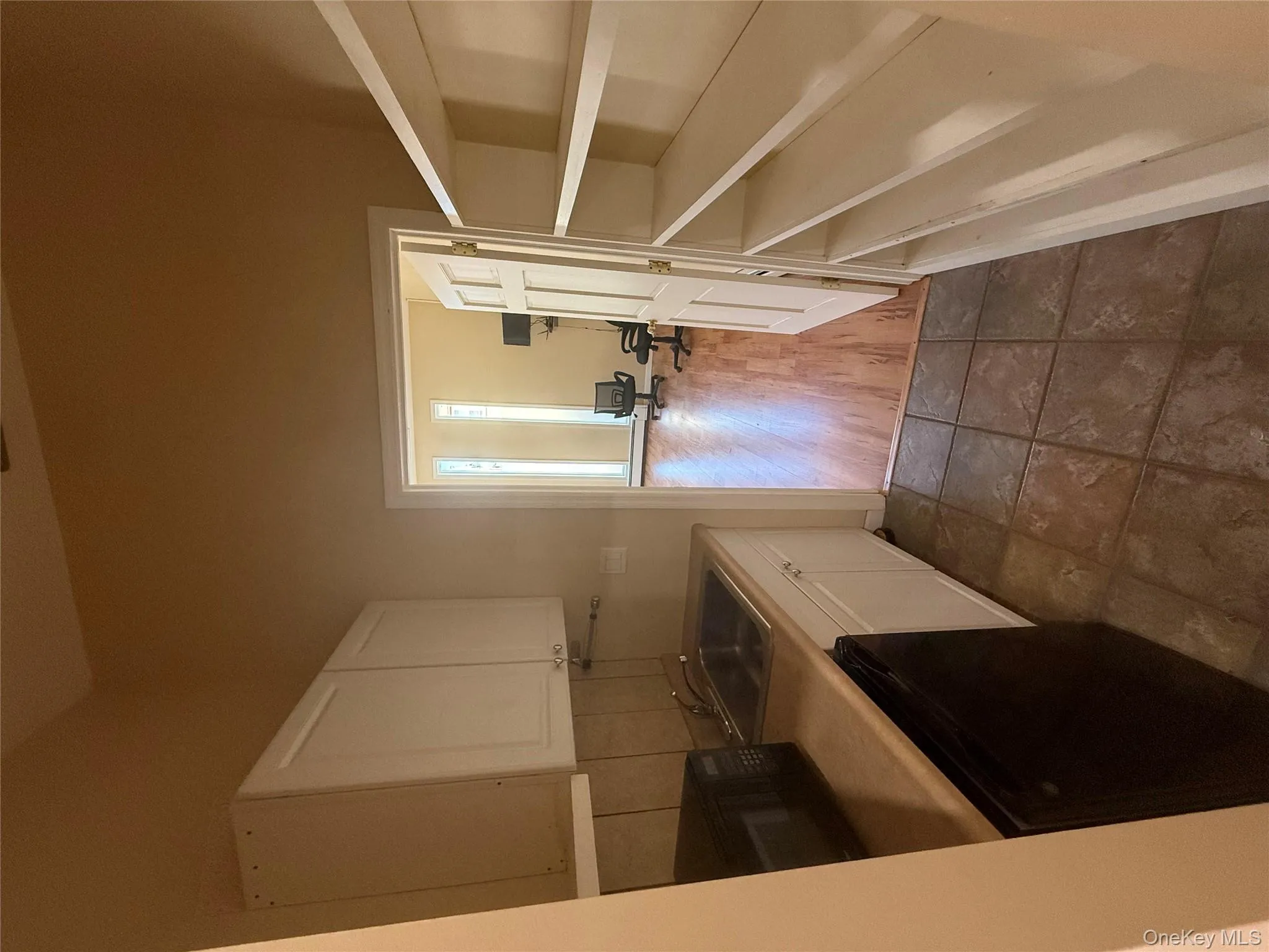 Kitchen featuring light countertops, dishwasher, and white cabinetry Kitchen featuring light countertops, dishwasher, and white cabinetry