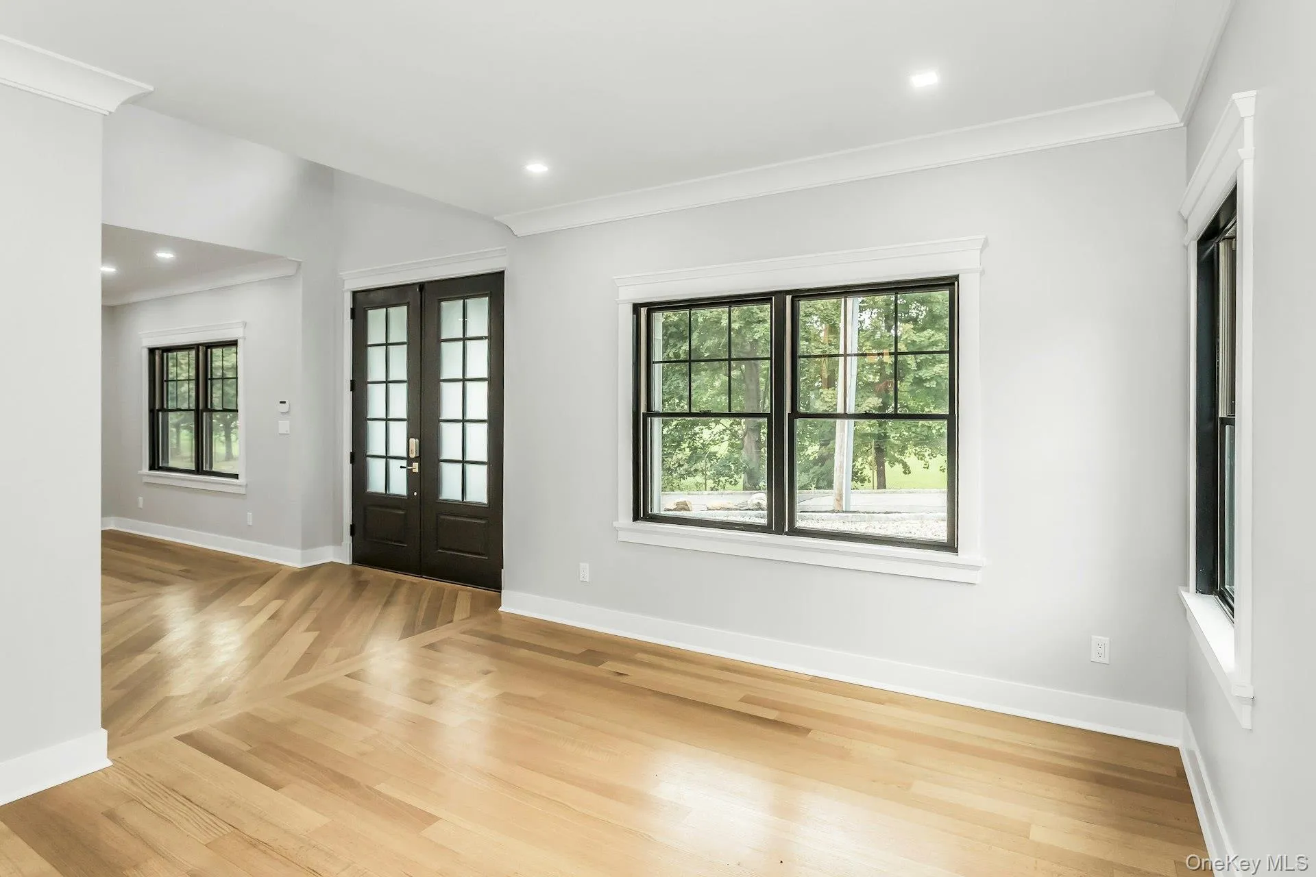 Entryway with crown molding, plenty of natural light, french doors, recessed lighting, and light wood-type flooring Entryway with crown molding, plenty of natural light, french doors, recessed lighting, and light wood-type flooring