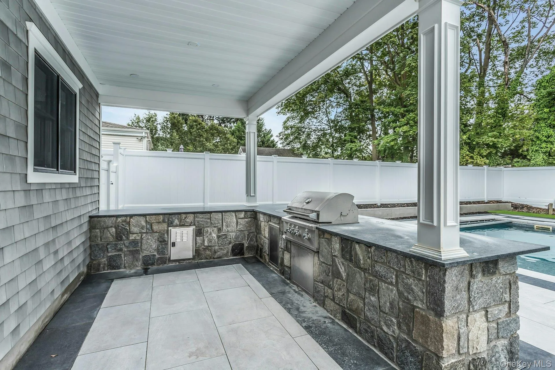 Fenced backyard featuring a patio area and exterior kitchen Fenced backyard featuring a patio area and exterior kitchen
