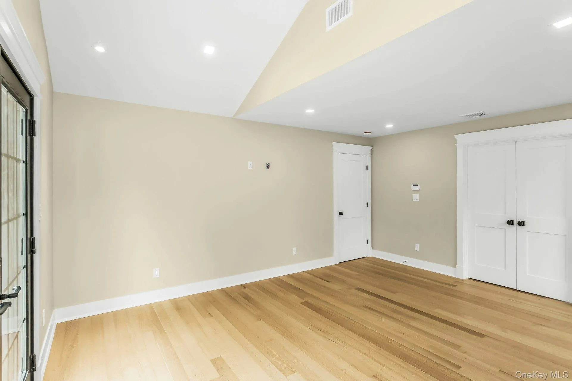 Unfurnished bedroom featuring recessed lighting, light wood finished floors, lofted ceiling, and a closet Unfurnished bedroom featuring recessed lighting, light wood finished floors, lofted ceiling, and a closet
