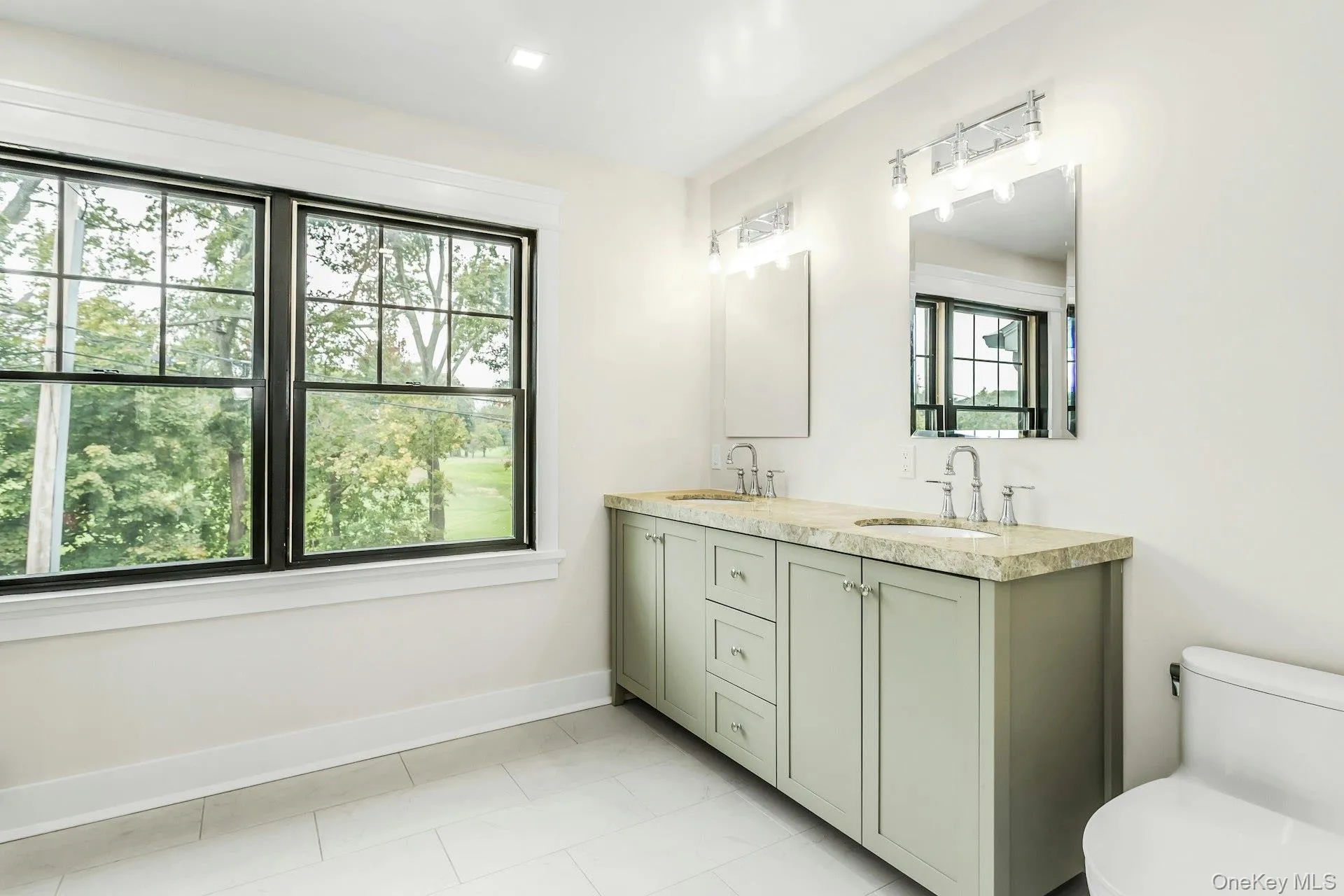 Full bathroom featuring double vanity and light tile patterned floors Full bathroom featuring double vanity and light tile patterned floors