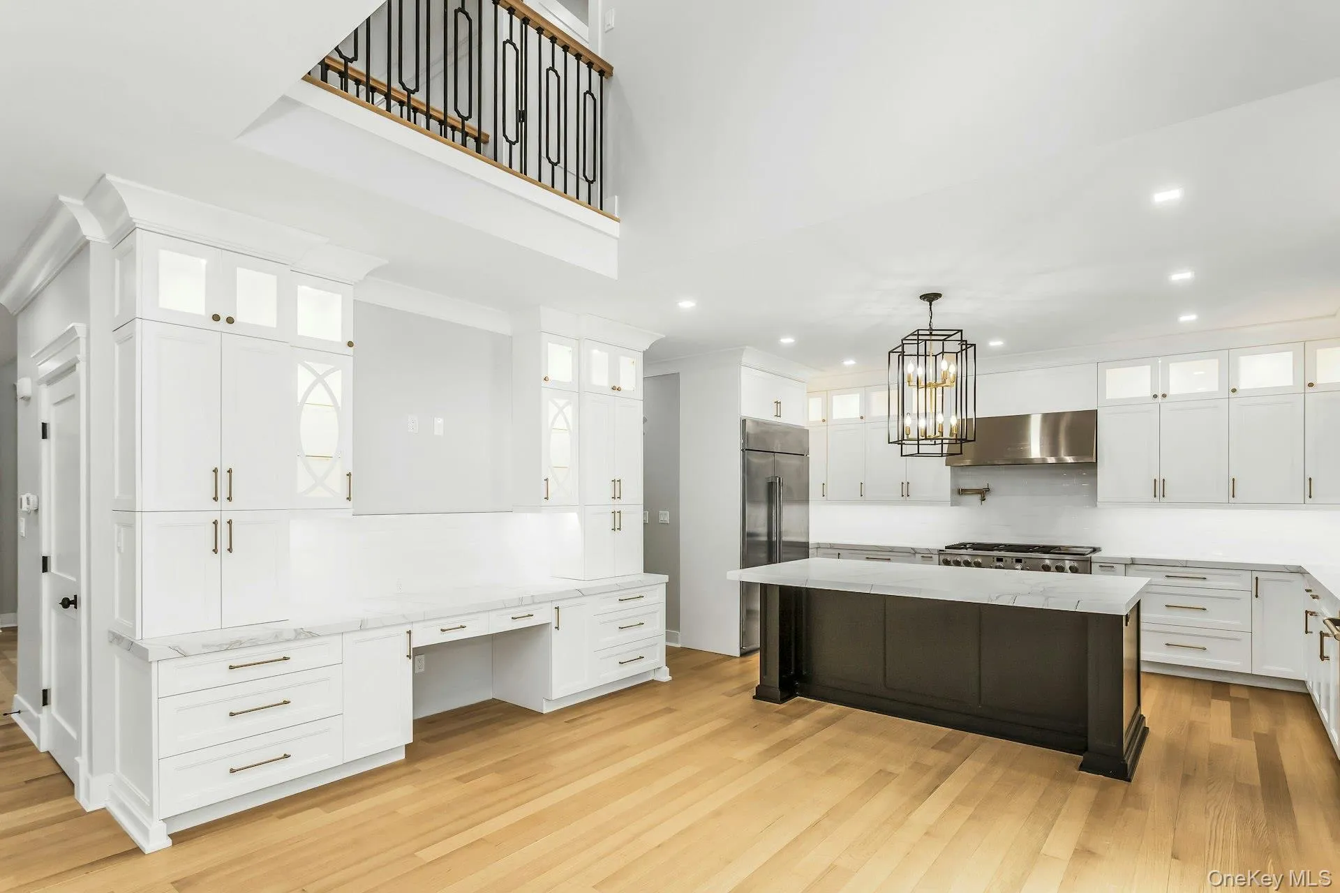 Kitchen featuring glass insert cabinets, white cabinetry, light stone countertops, recessed lighting, and ornamental molding Kitchen featuring glass insert cabinets, white cabinetry, light stone countertops, recessed lighting, and ornamental molding