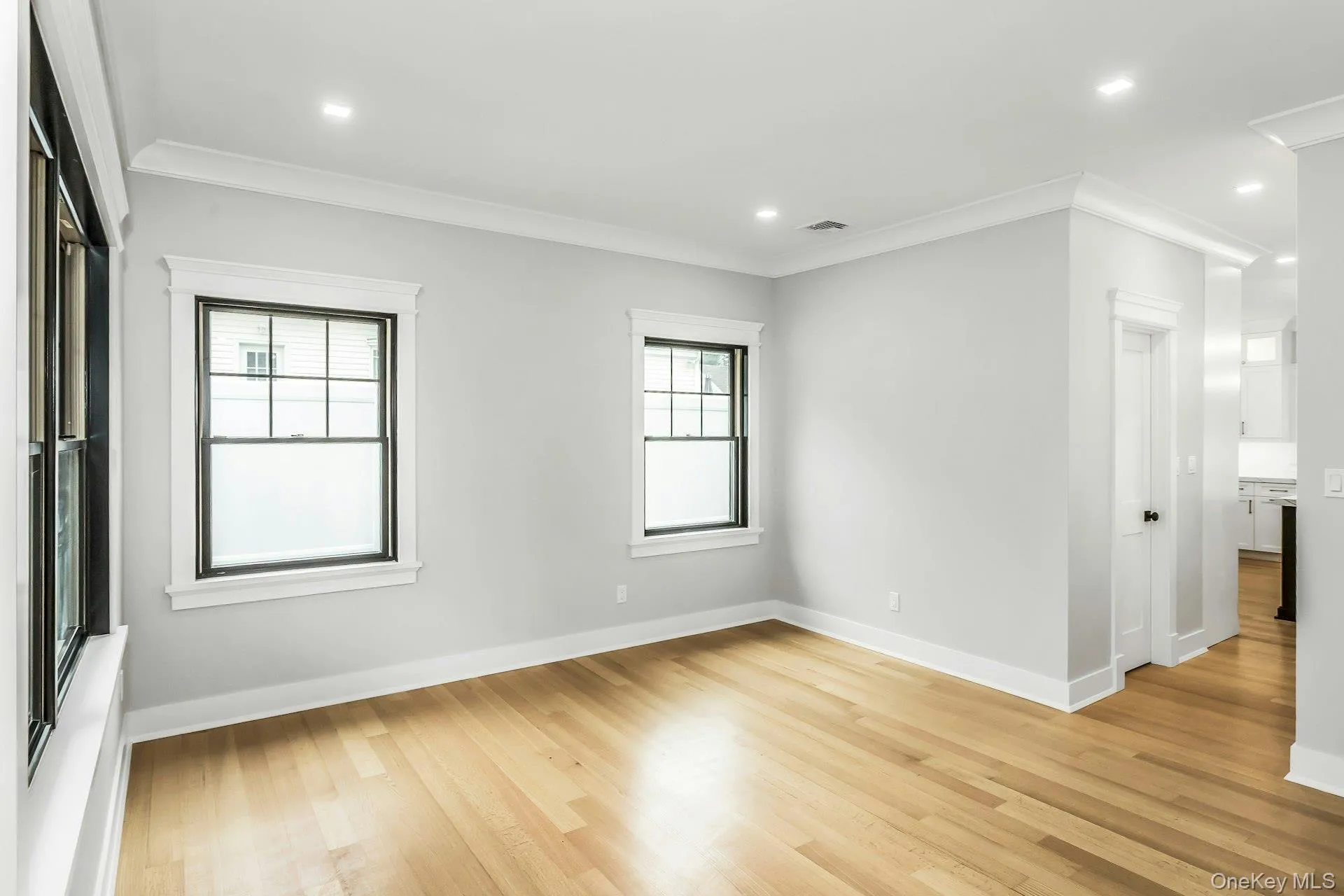 Empty room featuring ornamental molding, light wood-type flooring, and recessed lighting Empty room featuring ornamental molding, light wood-type flooring, and recessed lighting