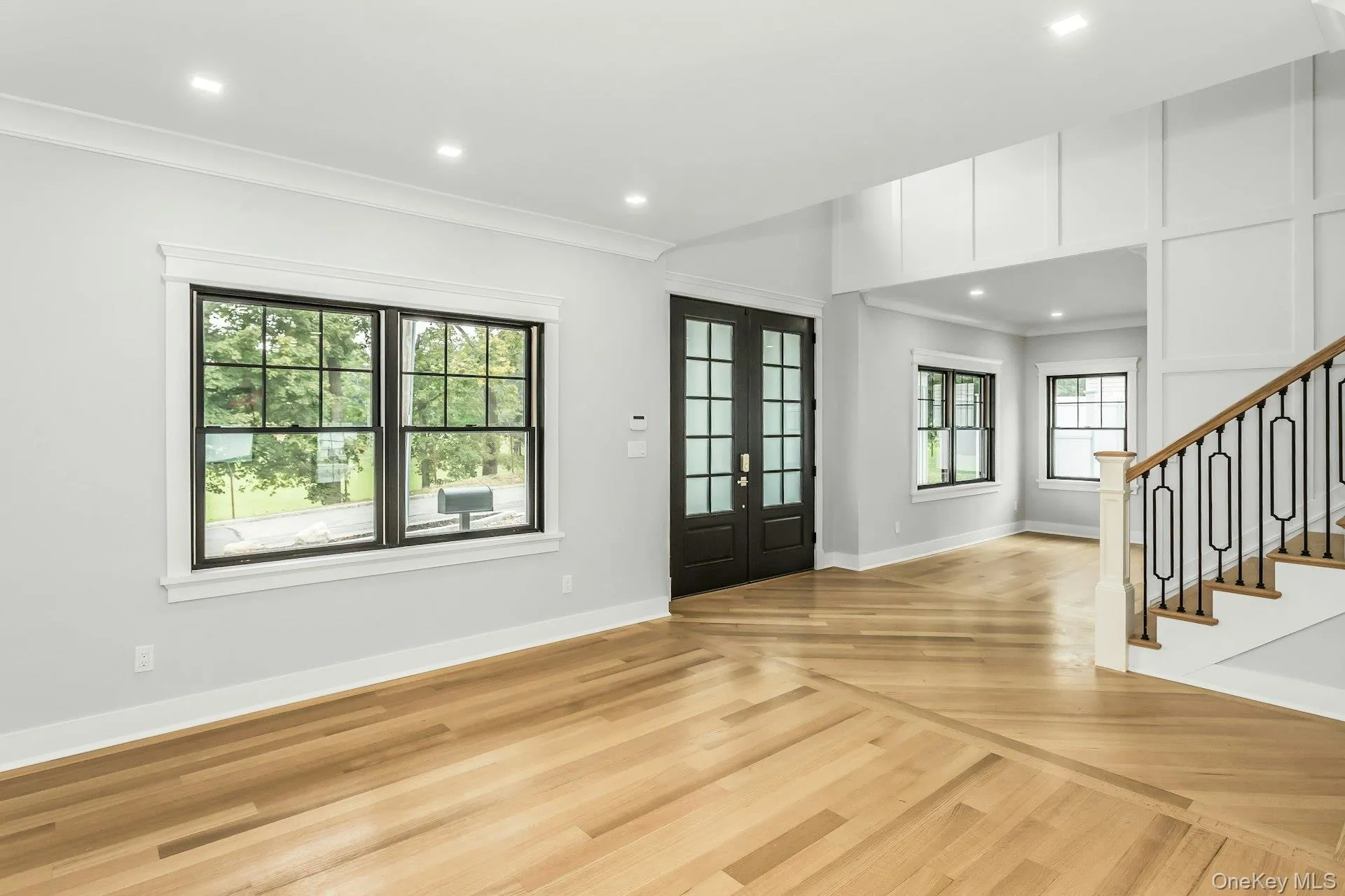 Entryway with crown molding, recessed lighting, french doors, stairway, and light wood finished floors Entryway with crown molding, recessed lighting, french doors, stairway, and light wood finished floors