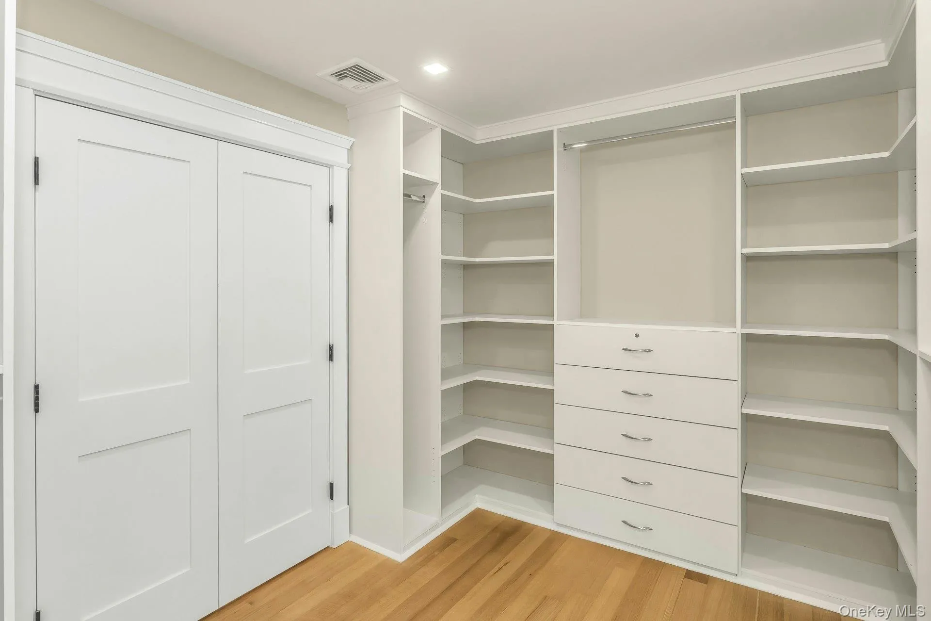 Spacious closet featuring light wood-style floors Spacious closet featuring light wood-style floors