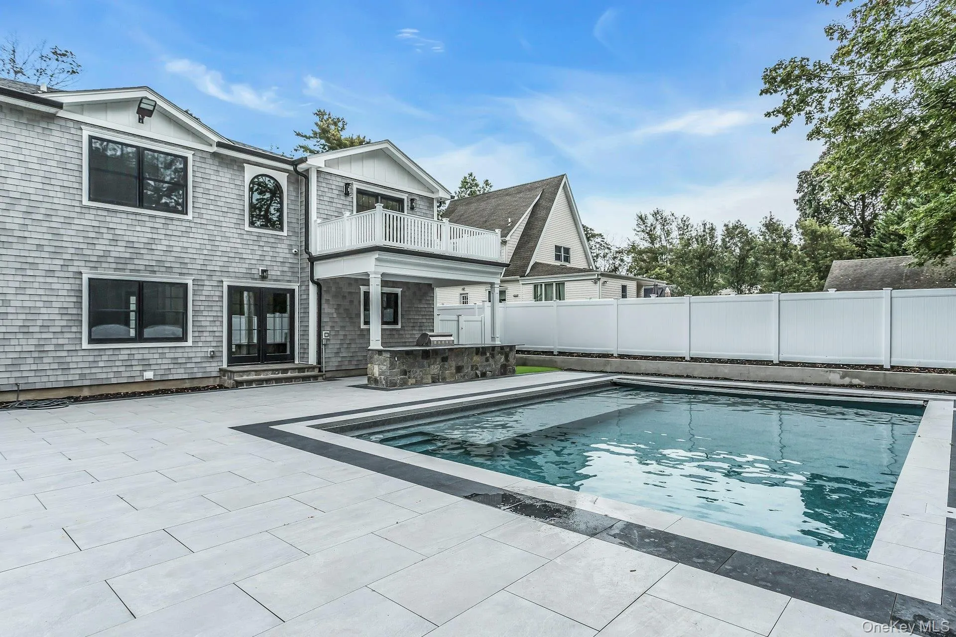 View of pool with a balcony, a patio, a fenced backyard, and french doors View of pool with a balcony, a patio, a fenced backyard, and french doors