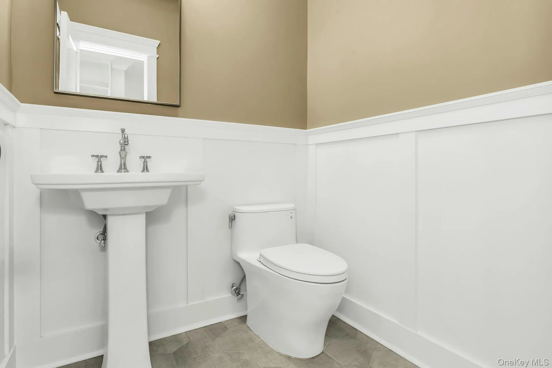 Half bath featuring toilet and wainscoting Half bath featuring toilet and wainscoting