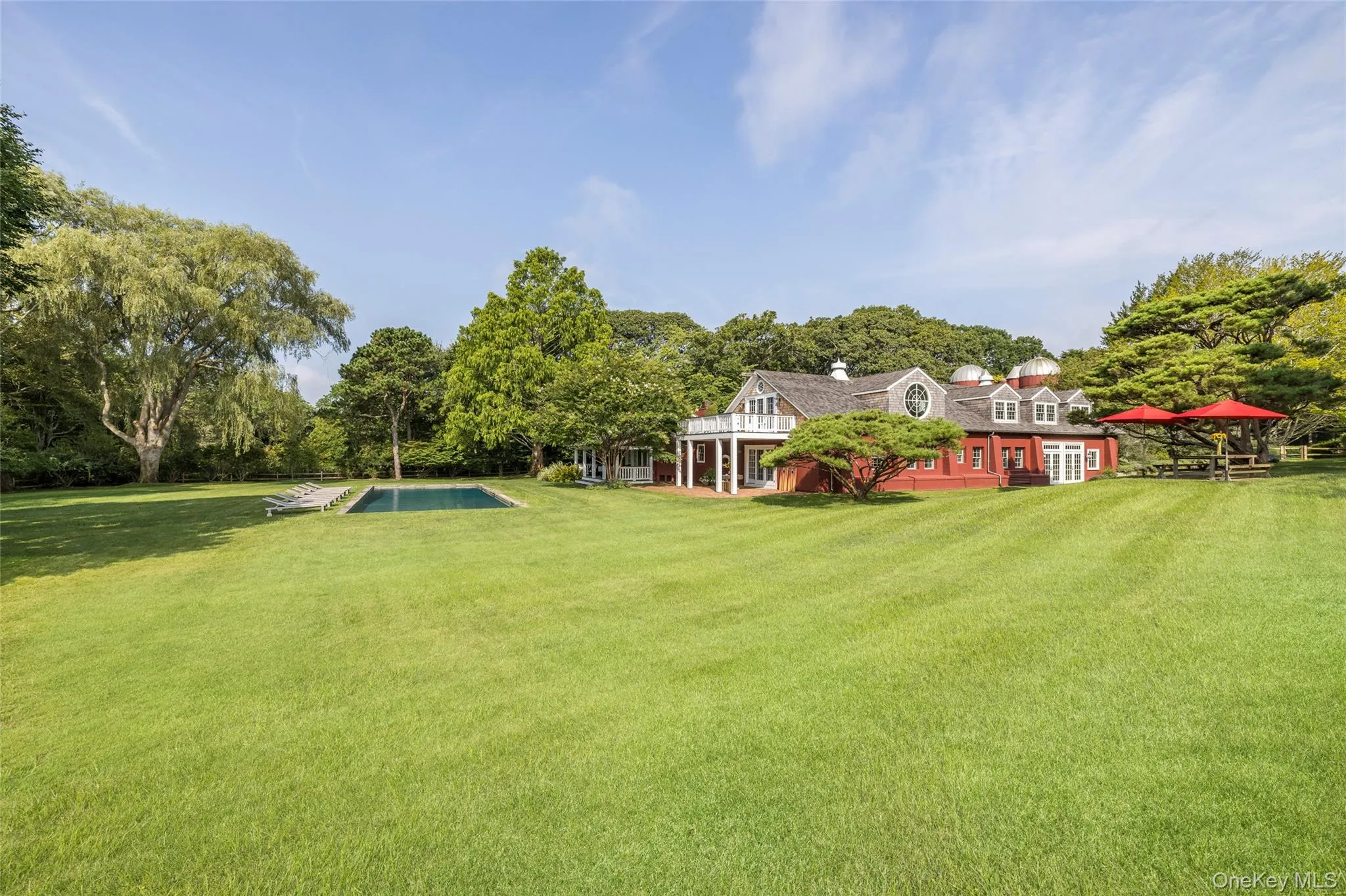 View of green lawn featuring covered porch and an outdoor pool View of green lawn featuring covered porch and an outdoor pool
