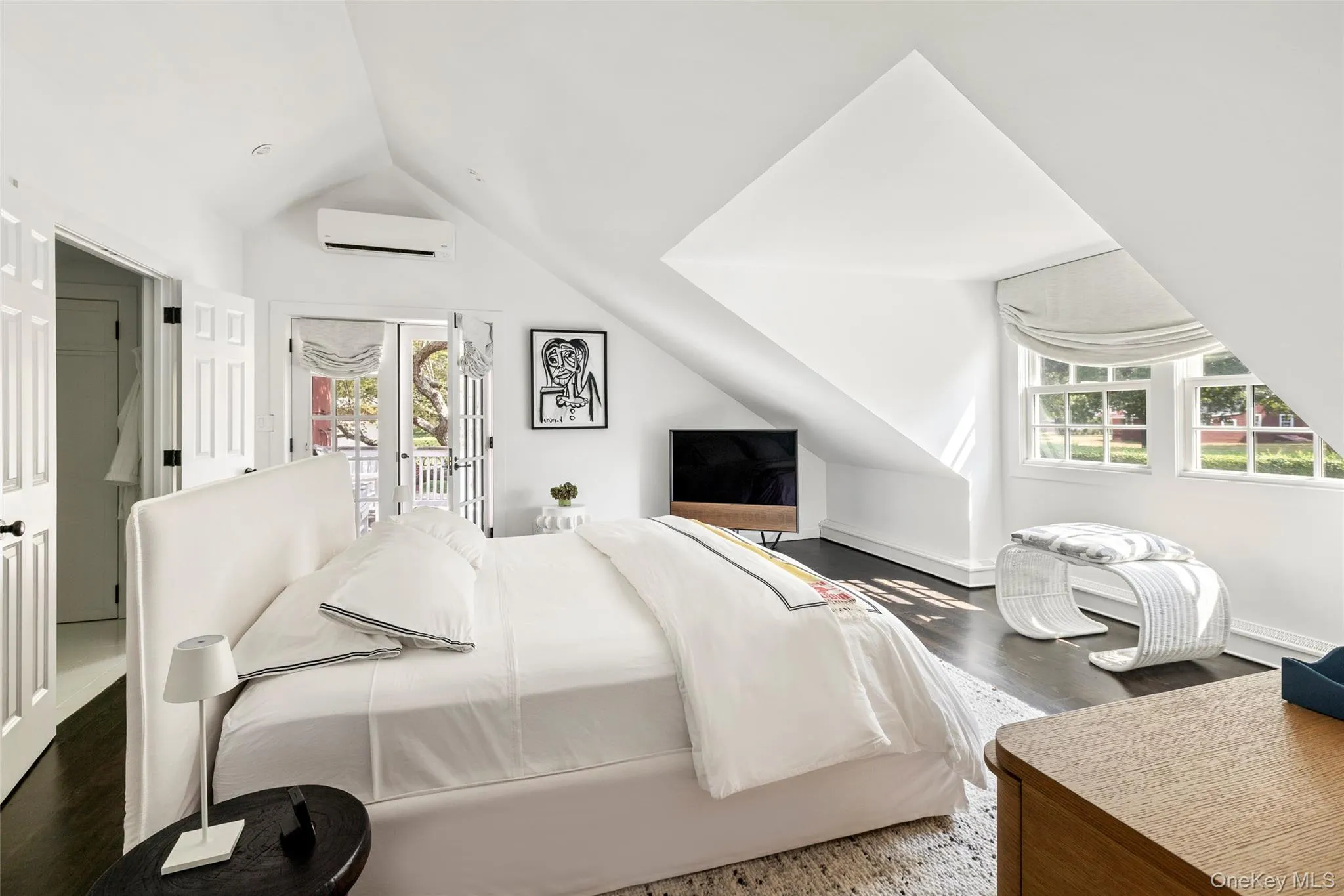 Bedroom with lofted ceiling, access to exterior, dark wood-style floors, and a wall mounted AC Bedroom with lofted ceiling, access to exterior, dark wood-style floors, and a wall mounted AC