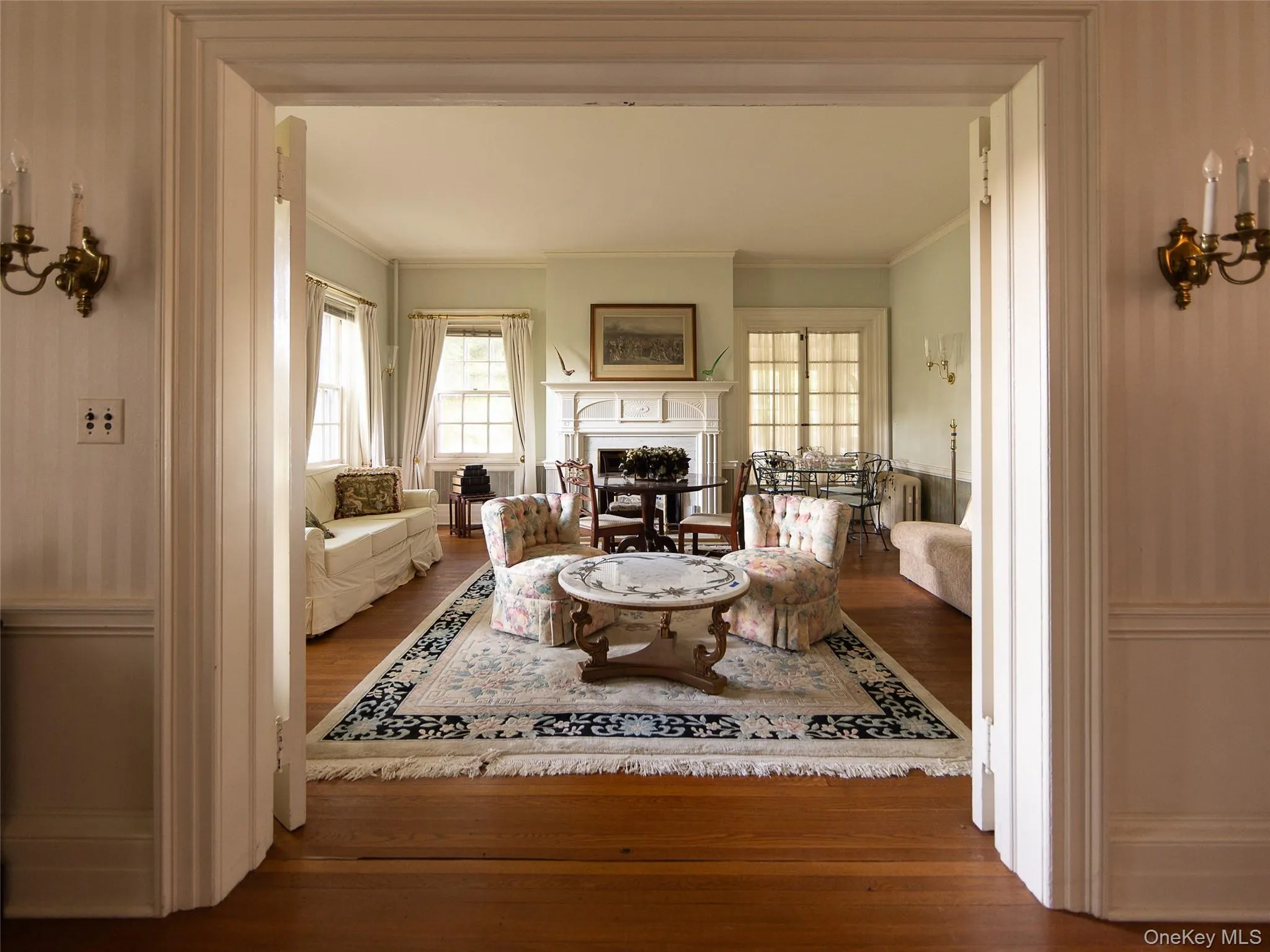Living room with dark wood-type flooring, a fireplace, and ornamental molding Living room with dark wood-type flooring, a fireplace, and ornamental molding