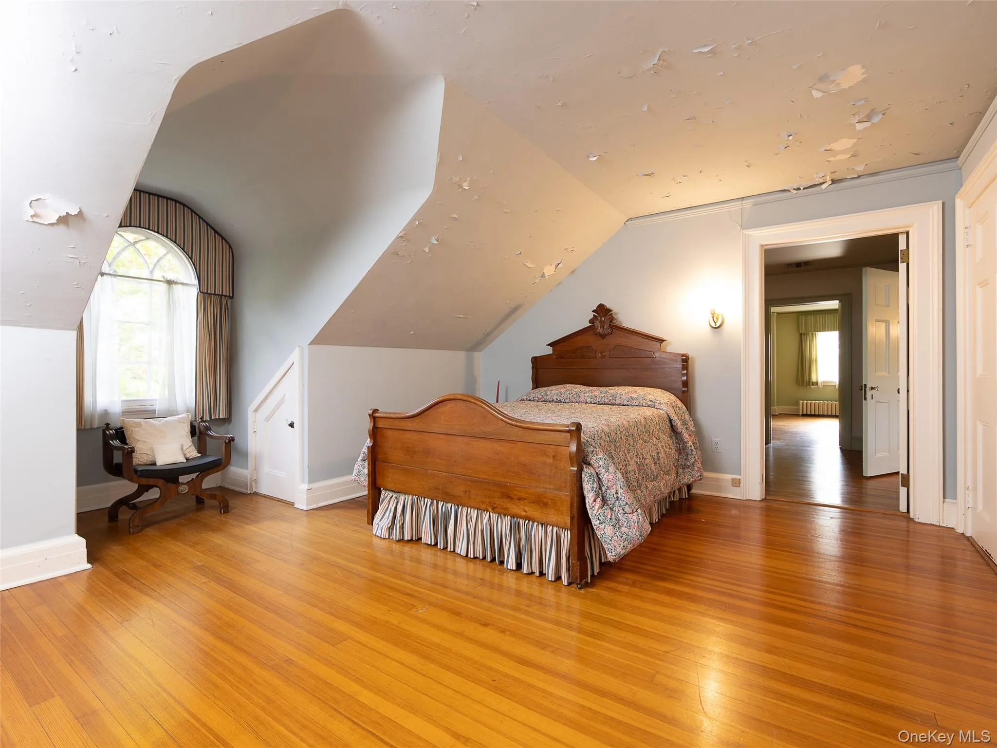 Bedroom featuring light wood finished floors, multiple windows, and vaulted ceiling Bedroom featuring light wood finished floors, multiple windows, and vaulted ceiling