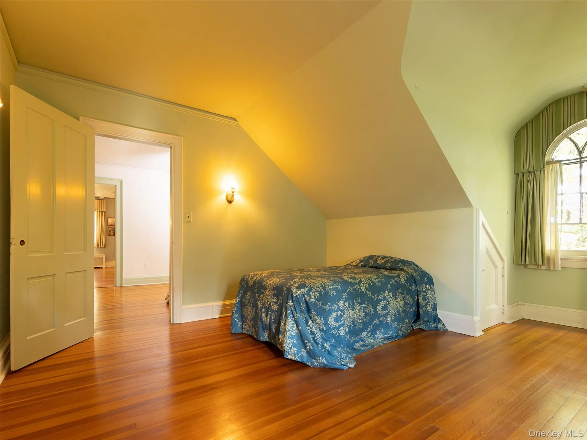 Bedroom featuring wood finished floors and lofted ceiling Bedroom featuring wood finished floors and lofted ceiling