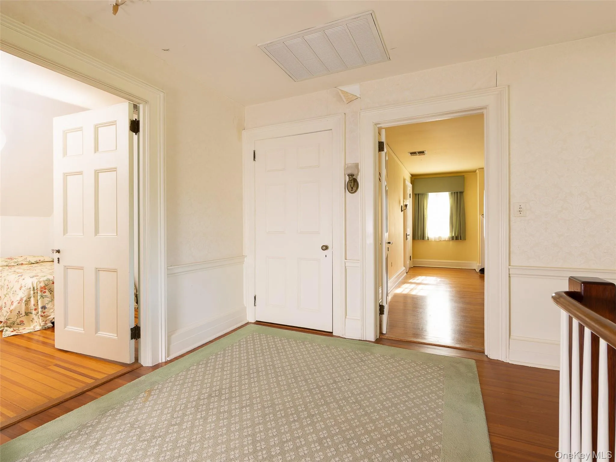 Hallway with wood finished floors and a wainscoted wall Hallway with wood finished floors and a wainscoted wall