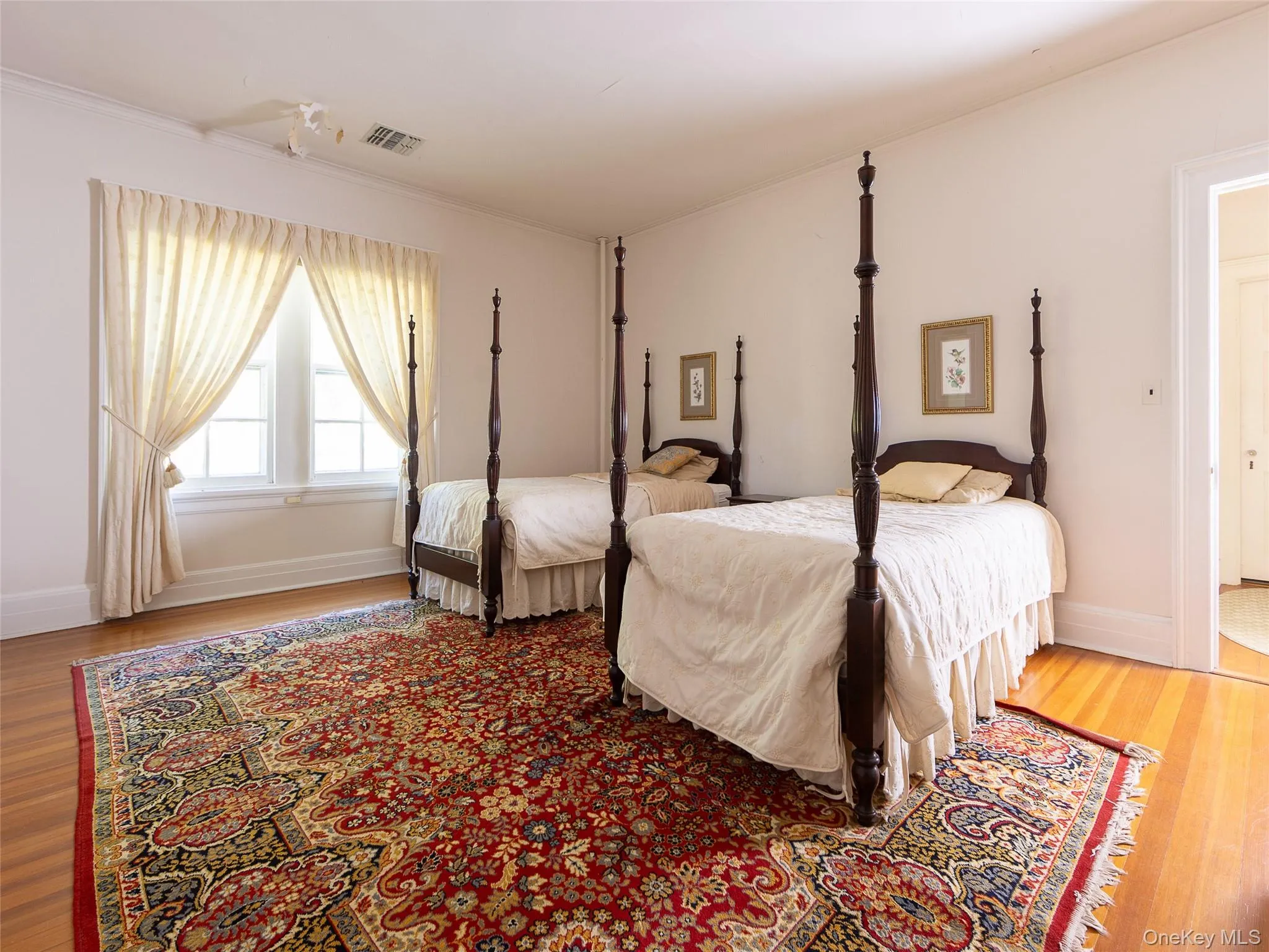 Bedroom featuring light wood-type flooring and ornamental molding Bedroom featuring light wood-type flooring and ornamental molding