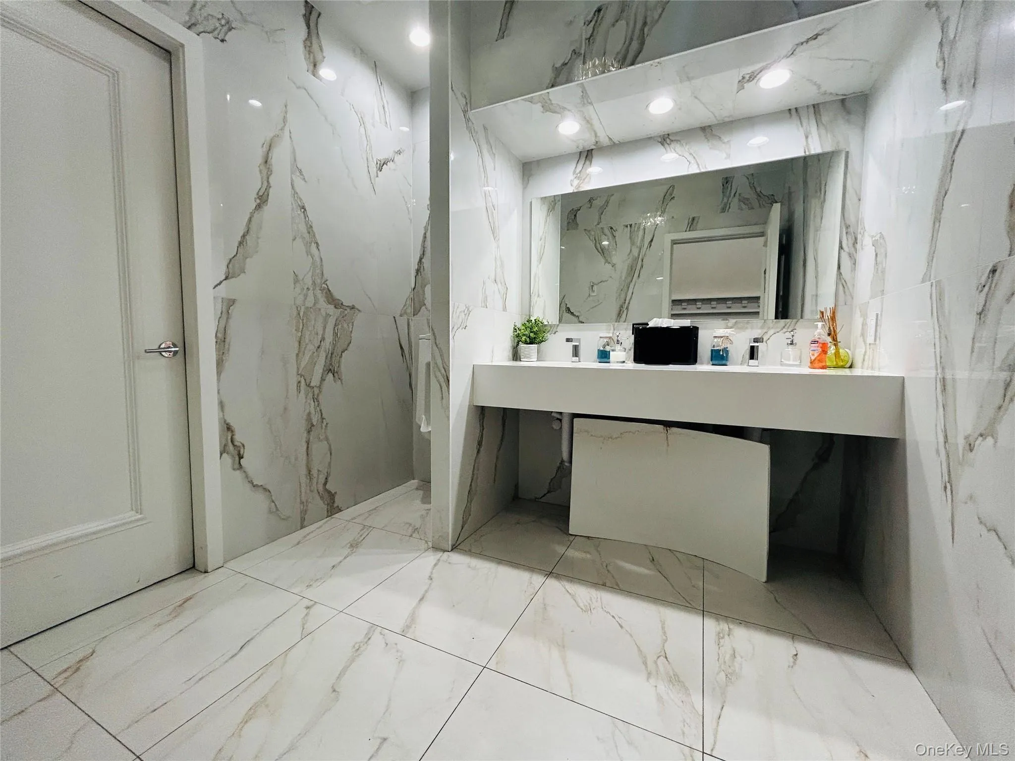 Bathroom with vanity, stone wall, marble finish floors, and recessed lighting Bathroom with vanity, stone wall, marble finish floors, and recessed lighting