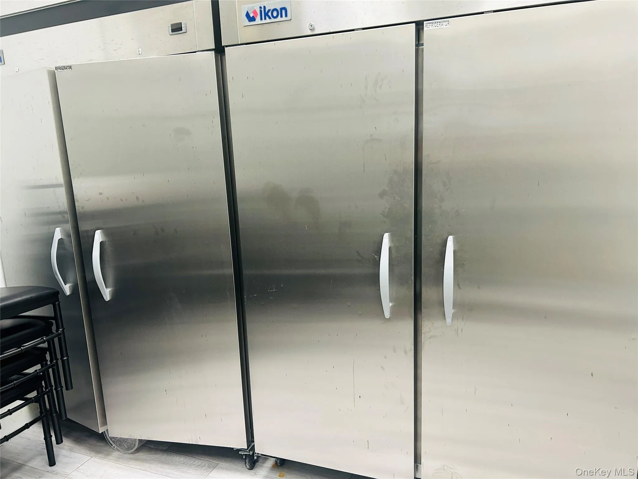 Kitchen view of stainless steel refrigerator and wood finished floors Kitchen view of stainless steel refrigerator and wood finished floors