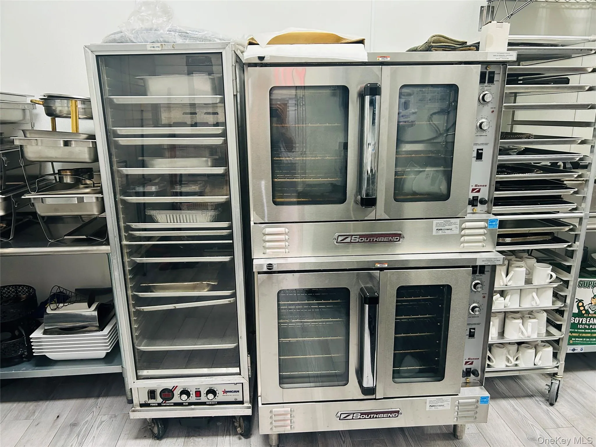 Kitchen view of beverage cooler, light wood-type flooring, and stainless steel oven Kitchen view of beverage cooler, light wood-type flooring, and stainless steel oven
