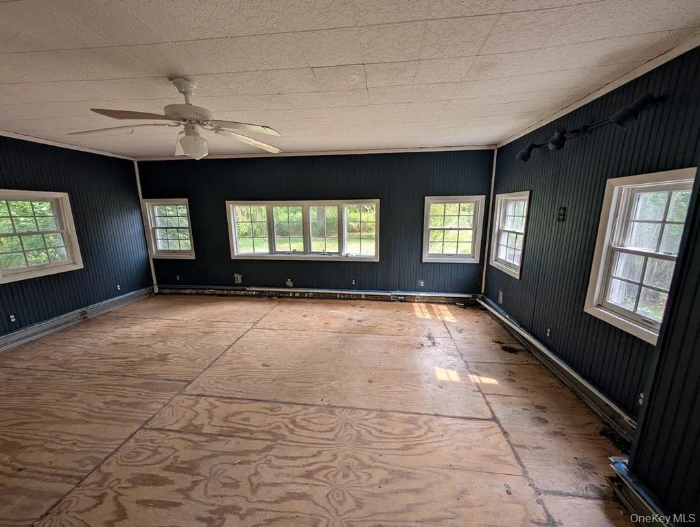 Unfurnished room with healthy amount of natural light and a ceiling fan Unfurnished room with healthy amount of natural light and a ceiling fan