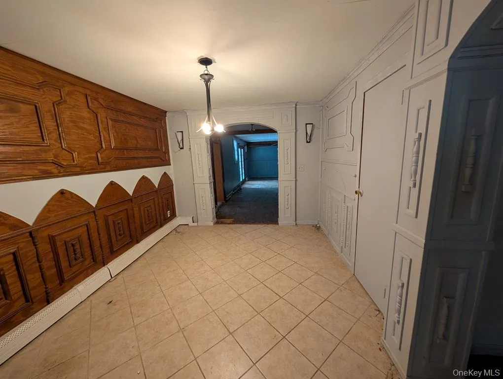 Hall featuring arched walkways and light tile patterned floors Hall featuring arched walkways and light tile patterned floors