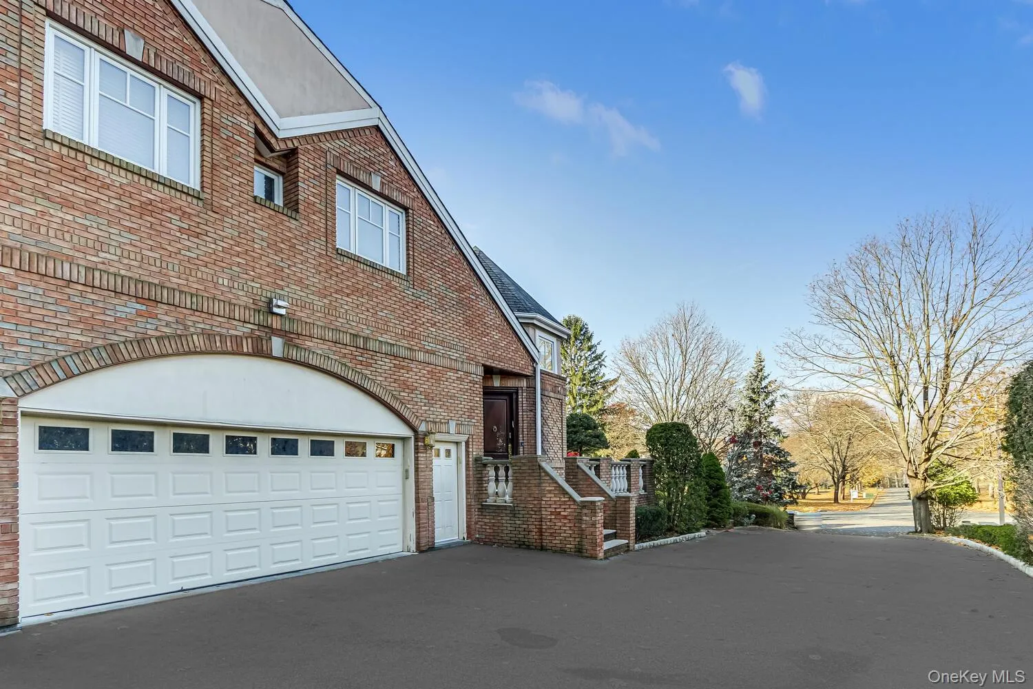 View of property exterior with brick siding, a garage, and asphalt driveway View of property exterior with brick siding, a garage, and asphalt driveway