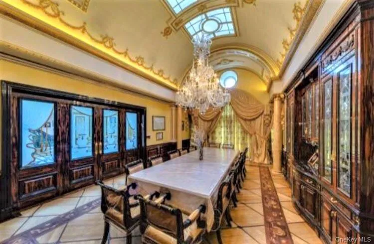 Dining room with hand painted gold leaf ceiling accents, french doors and tile patterned flooring with inlay Dining room with hand painted gold leaf ceiling accents, french doors and tile patterned flooring with inlay