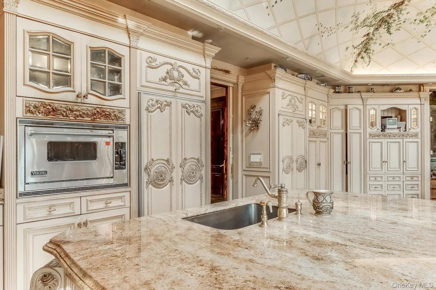 Kitchen featuring glass insert cabinets, oven, light stone countertops, and cream cabinets Kitchen featuring glass insert cabinets, oven, light stone countertops, and cream cabinets