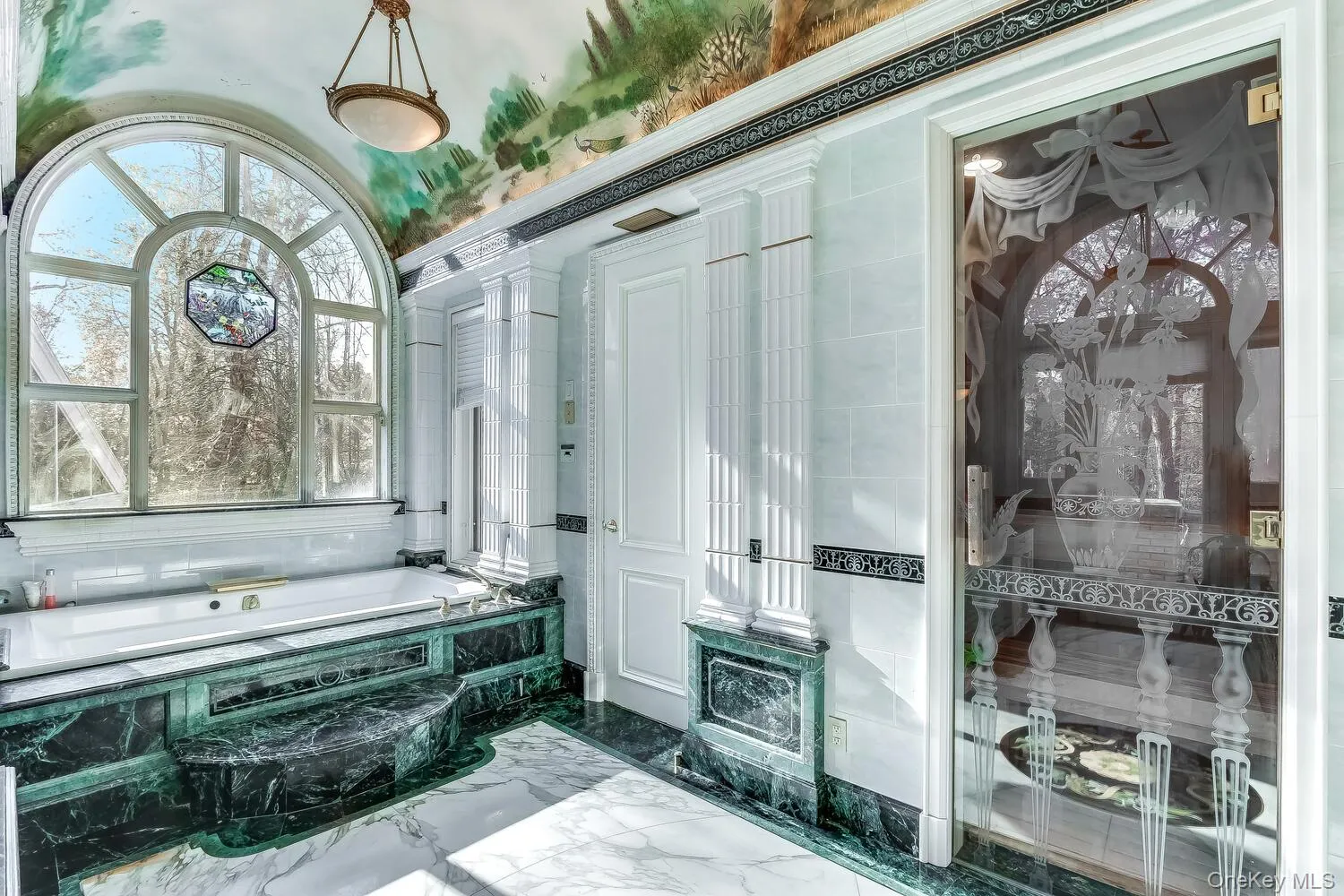 Full bath featuring marble tiled flooring and a bath Full bath featuring marble tiled flooring and a bath
