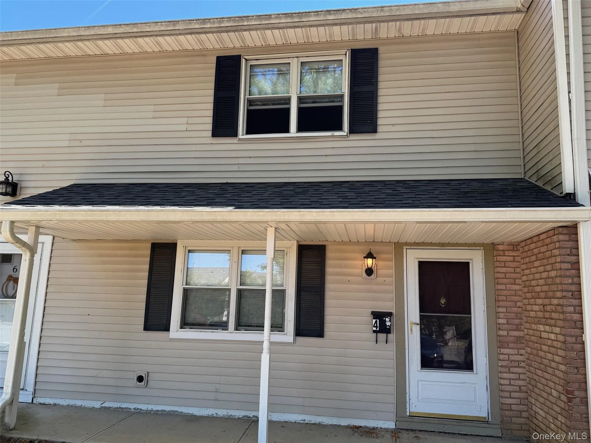 Doorway to property featuring covered porch and roof with shingles Doorway to property featuring covered porch and roof with shingles
