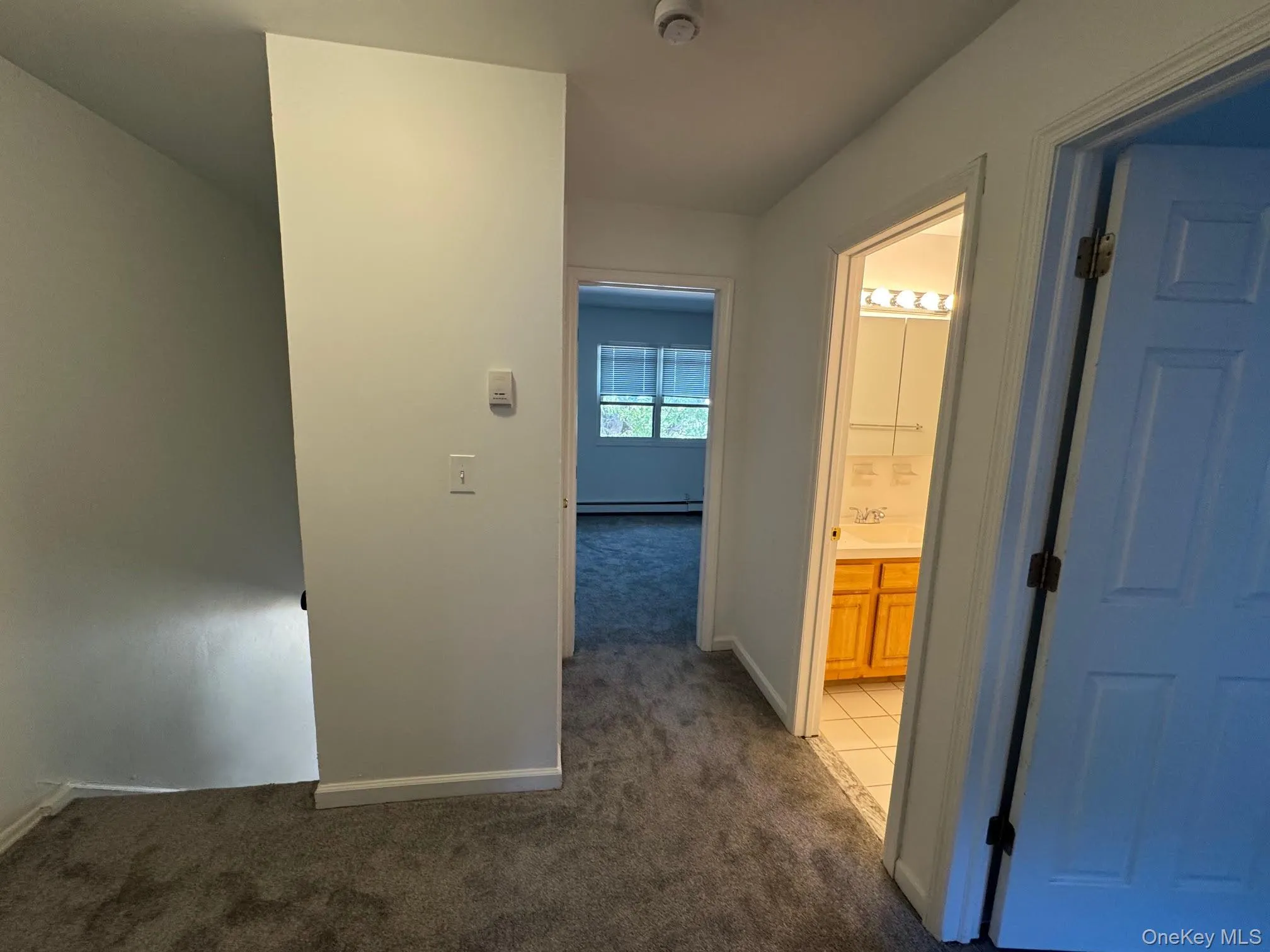 Corridor featuring dark carpet and dark tile patterned flooring Corridor featuring dark carpet and dark tile patterned flooring