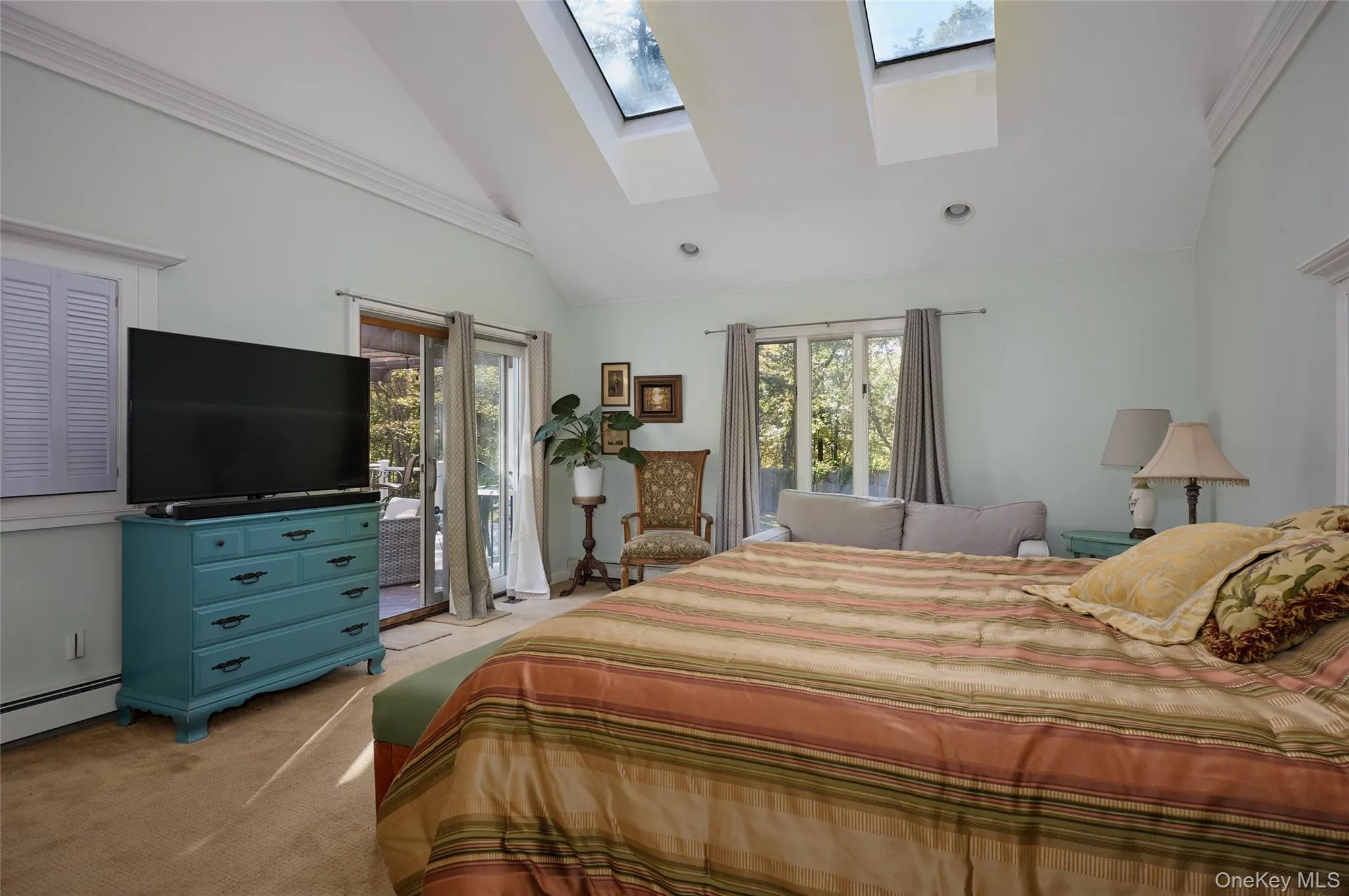 Bedroom with light colored carpet, high vaulted ceiling, access to exterior, a skylight, and recessed lighting Bedroom with light colored carpet, high vaulted ceiling, access to exterior, a skylight, and recessed lighting