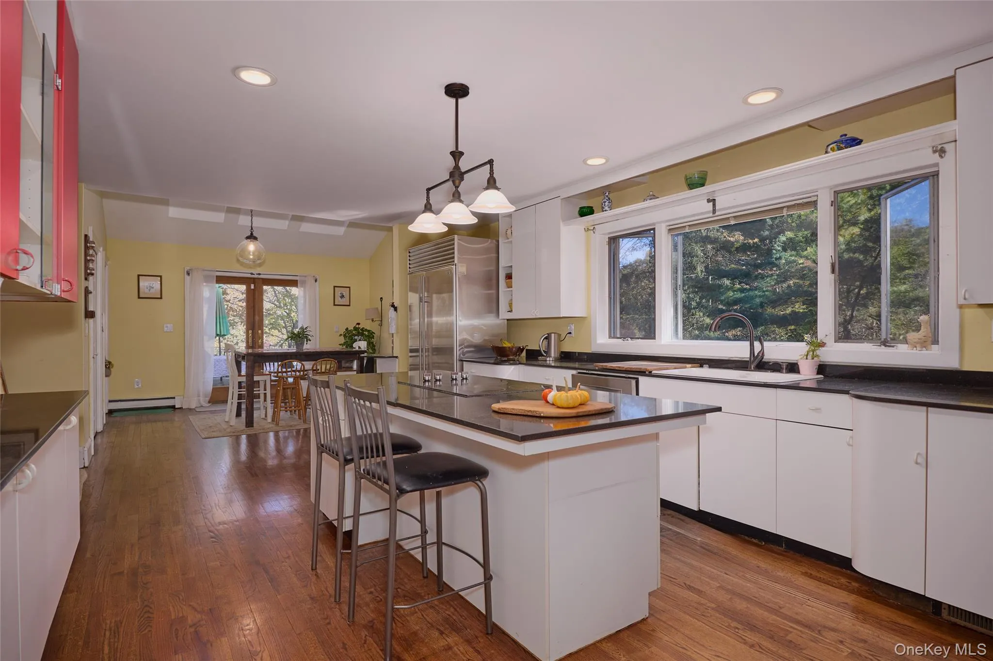 Kitchen featuring dark countertops, white cabinetry, pendant lighting, dark wood-style floors, and recessed lighting Kitchen featuring dark countertops, white cabinetry, pendant lighting, dark wood-style floors, and recessed lighting