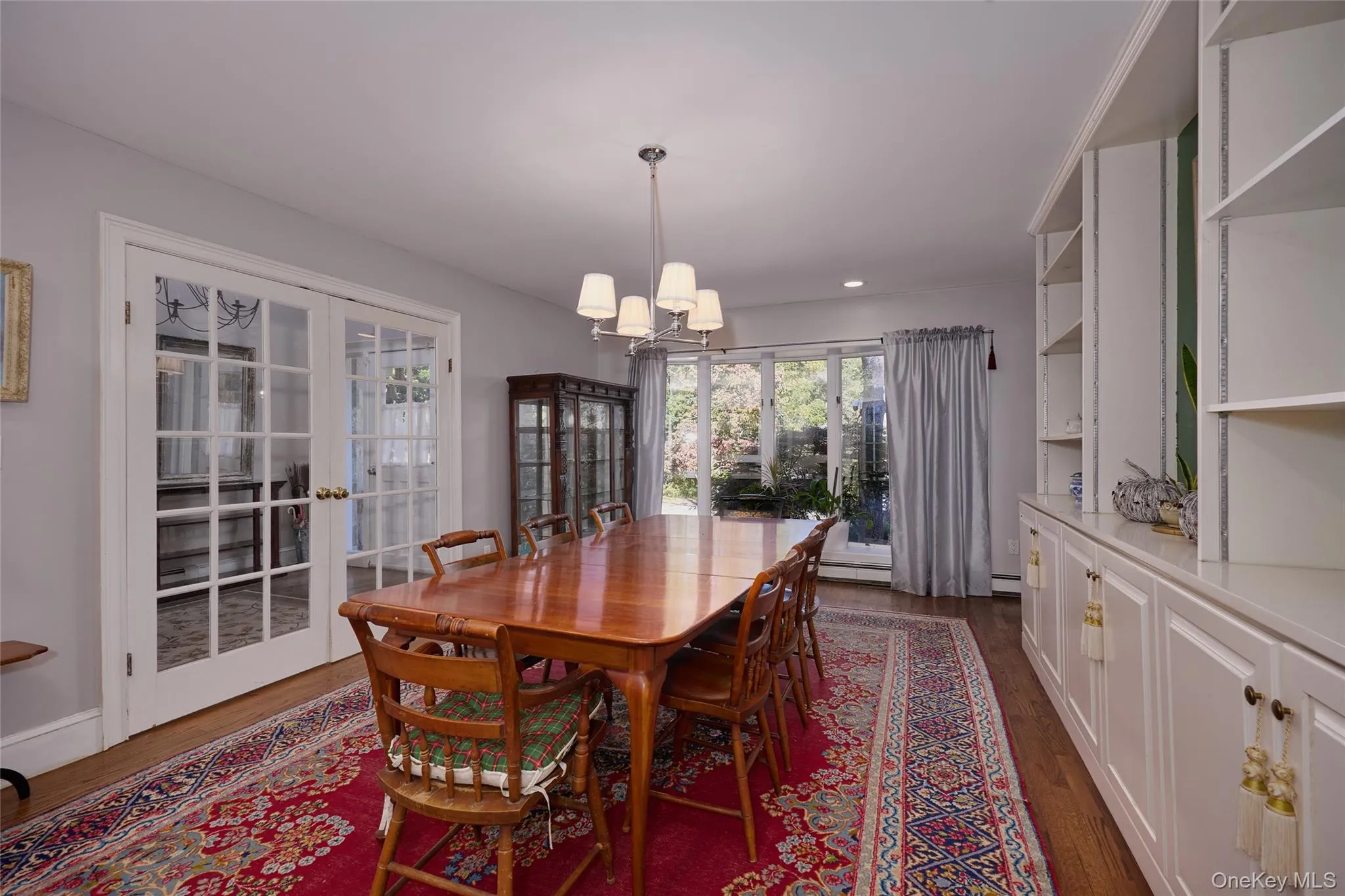 Dining space featuring french doors, dark wood-style flooring, and a chandelier. Dining space featuring french doors, dark wood-style flooring, and a chandelier.