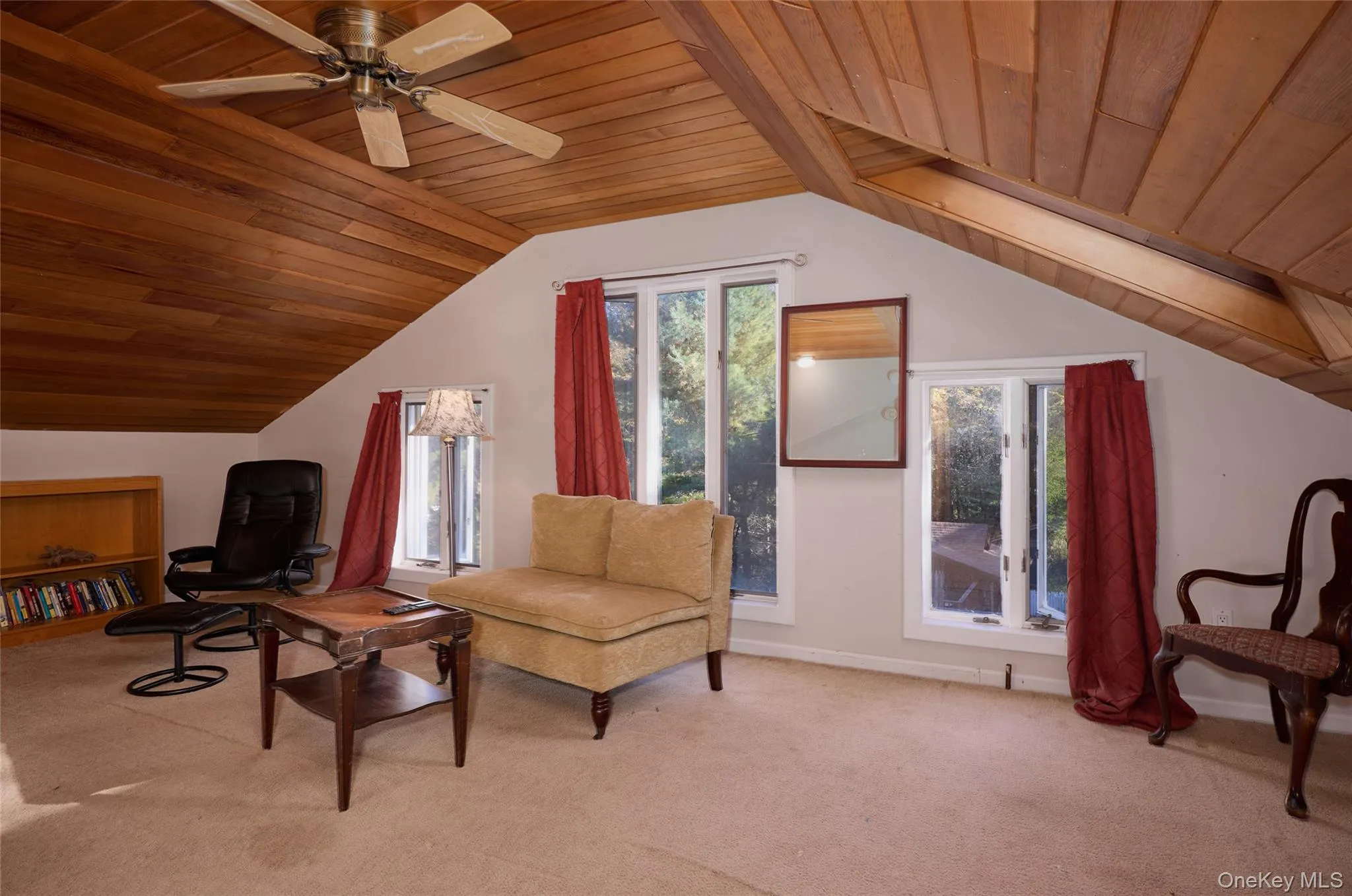 Upstairs Living area with wood ceiling, carpet flooring, vaulted ceiling, and a ceiling fan Upstairs Living area with wood ceiling, carpet flooring, vaulted ceiling, and a ceiling fan