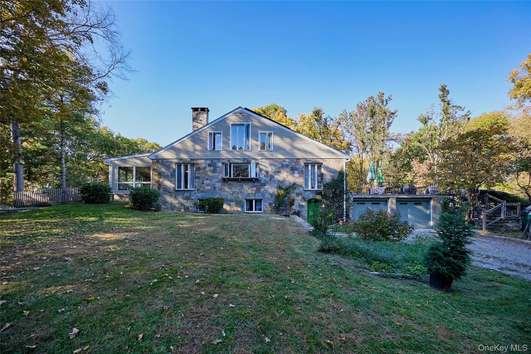 Back of property featuring a chimney and a garage Back of property featuring a chimney and a garage