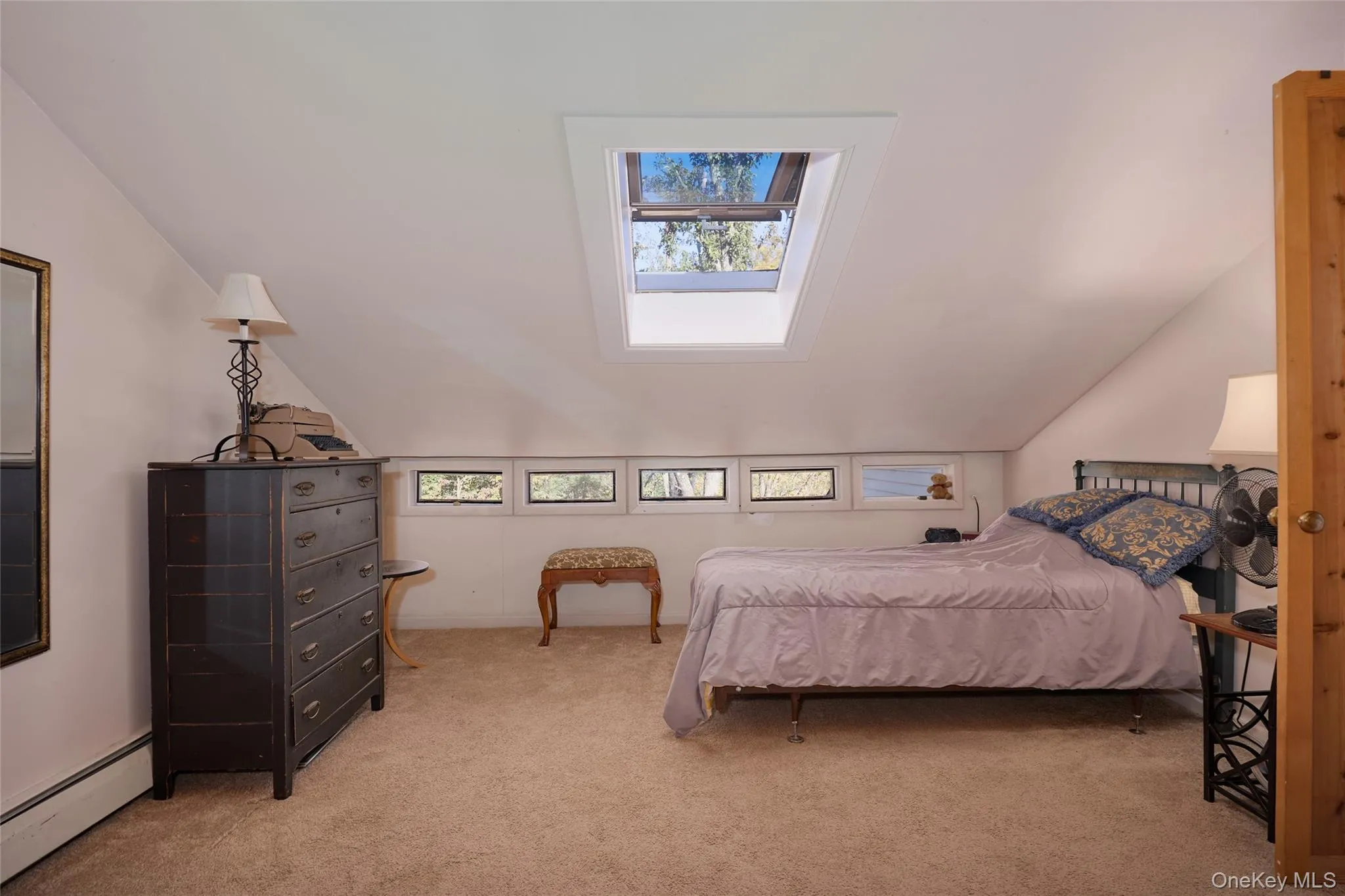 Upstairs Bedroom featuring baseboard heating, light carpet, and vaulted ceiling Upstairs Bedroom featuring baseboard heating, light carpet, and vaulted ceiling