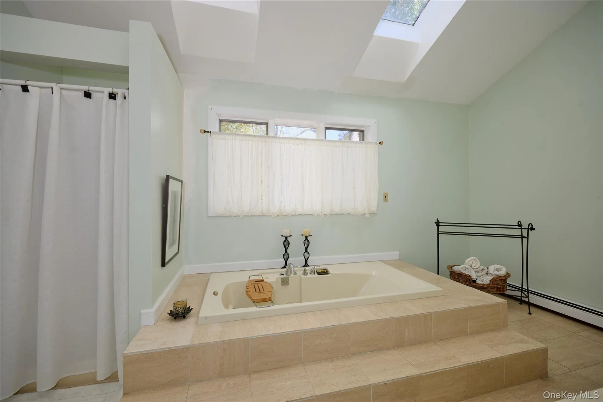 Full bathroom featuring a skylight, a garden tub, and a shower stall Full bathroom featuring a skylight, a garden tub, and a shower stall