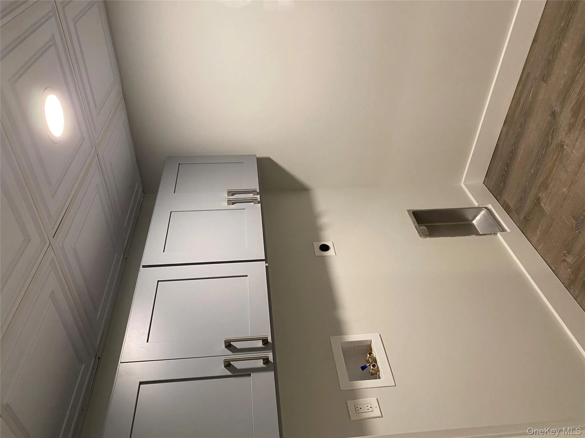 Laundry room featuring dark wood finished floors, cabinet space, hookup for a washing machine, hookup for an electric dryer, and recessed lighting Laundry room featuring dark wood finished floors, cabinet space, hookup for a washing machine, hookup for an electric dryer, and recessed lighting