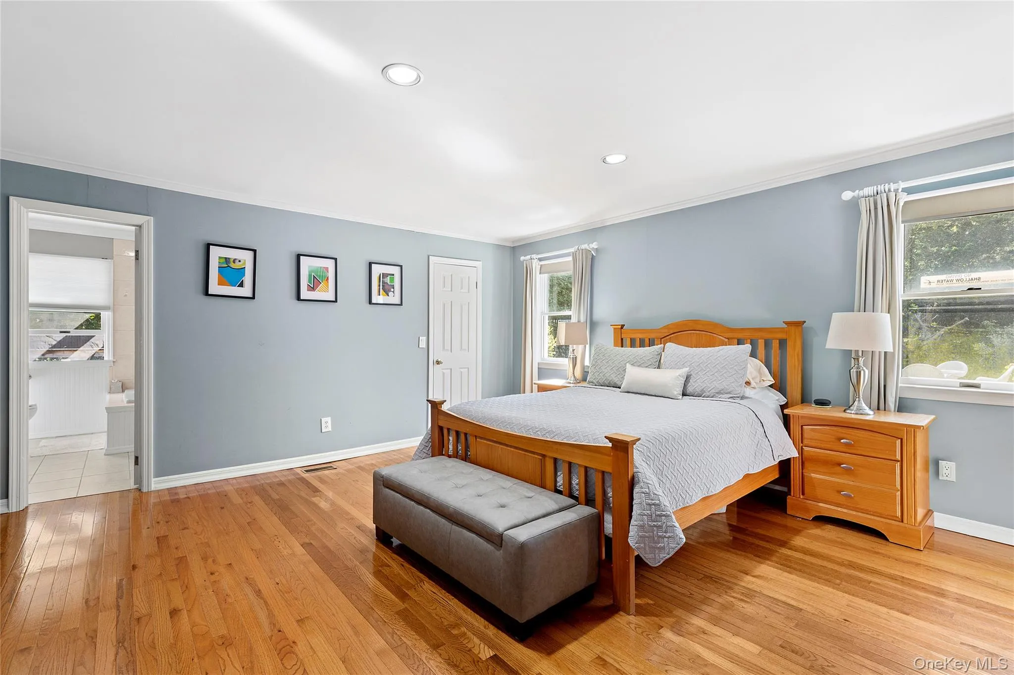 Bedroom featuring multiple windows, light wood finished floors, ornamental molding, and recessed lighting Bedroom featuring multiple windows, light wood finished floors, ornamental molding, and recessed lighting