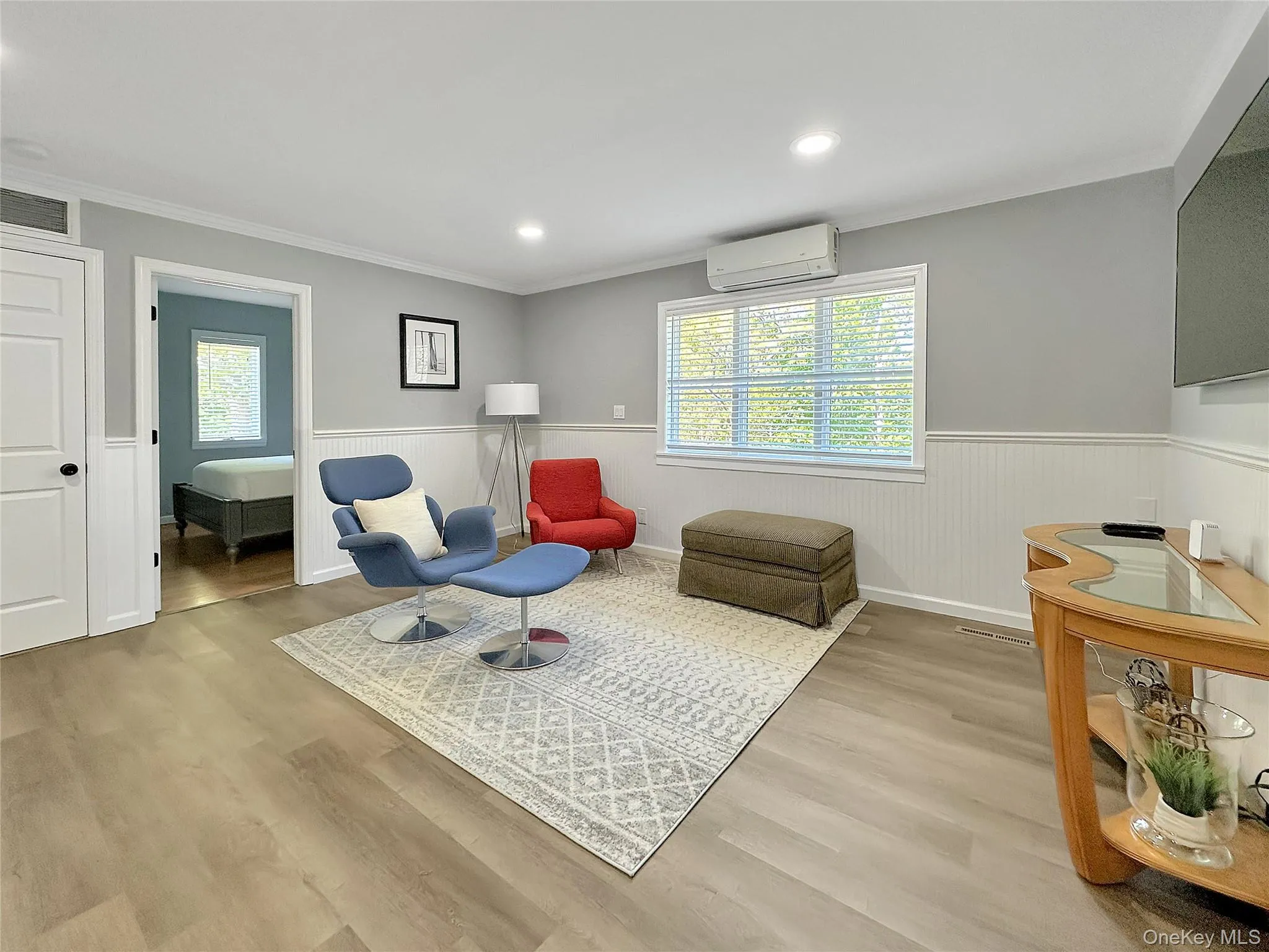 Sitting room featuring a wainscoted wall, ornamental molding, wood finished floors, recessed lighting, and a wall unit AC Sitting room featuring a wainscoted wall, ornamental molding, wood finished floors, recessed lighting, and a wall unit AC