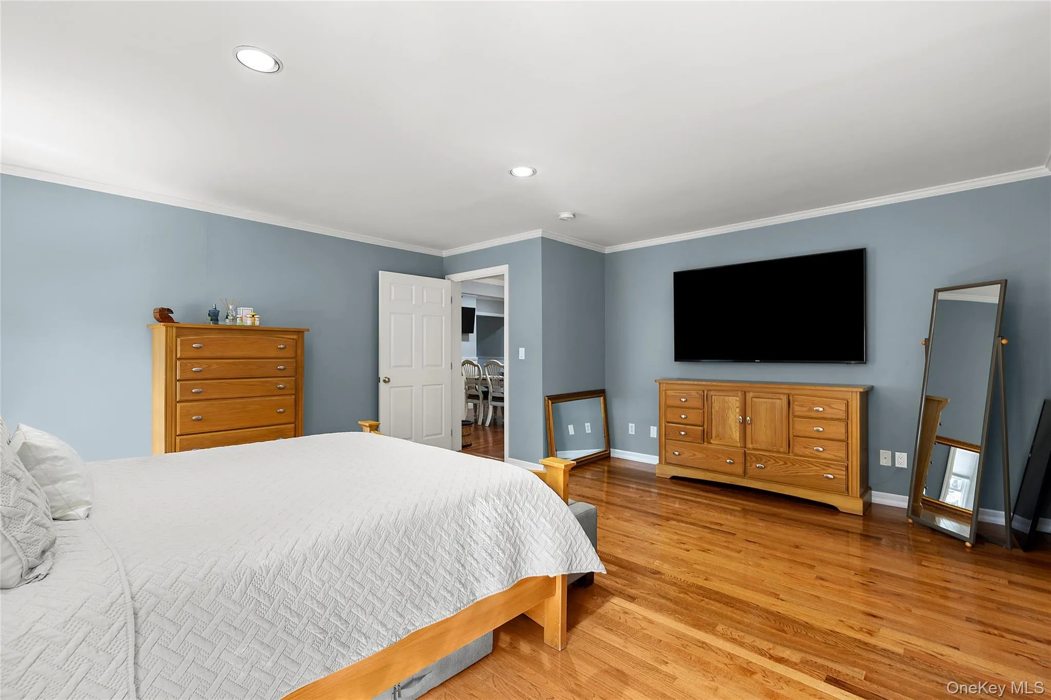 Bedroom featuring ornamental molding, light wood-style flooring, and recessed lighting Bedroom featuring ornamental molding, light wood-style flooring, and recessed lighting