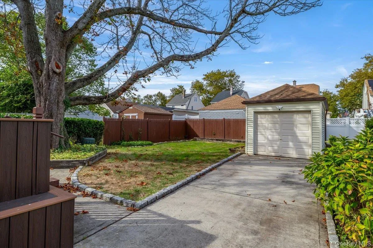 Fenced backyard featuring concrete driveway Fenced backyard featuring concrete driveway