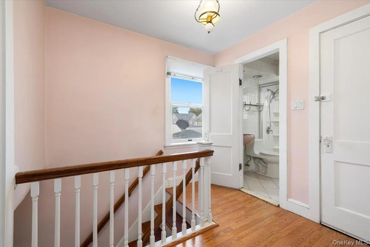 Corridor with light wood finished floors and an upstairs landing Corridor with light wood finished floors and an upstairs landing