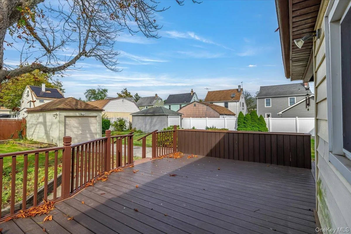 Wooden terrace with a residential view, a fenced backyard, and a shed Wooden terrace with a residential view, a fenced backyard, and a shed