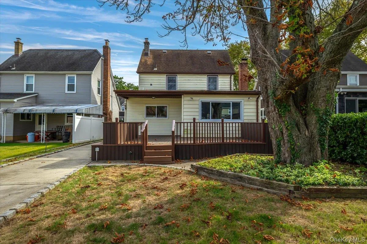 Back of house with a deck and a chimney Back of house with a deck and a chimney