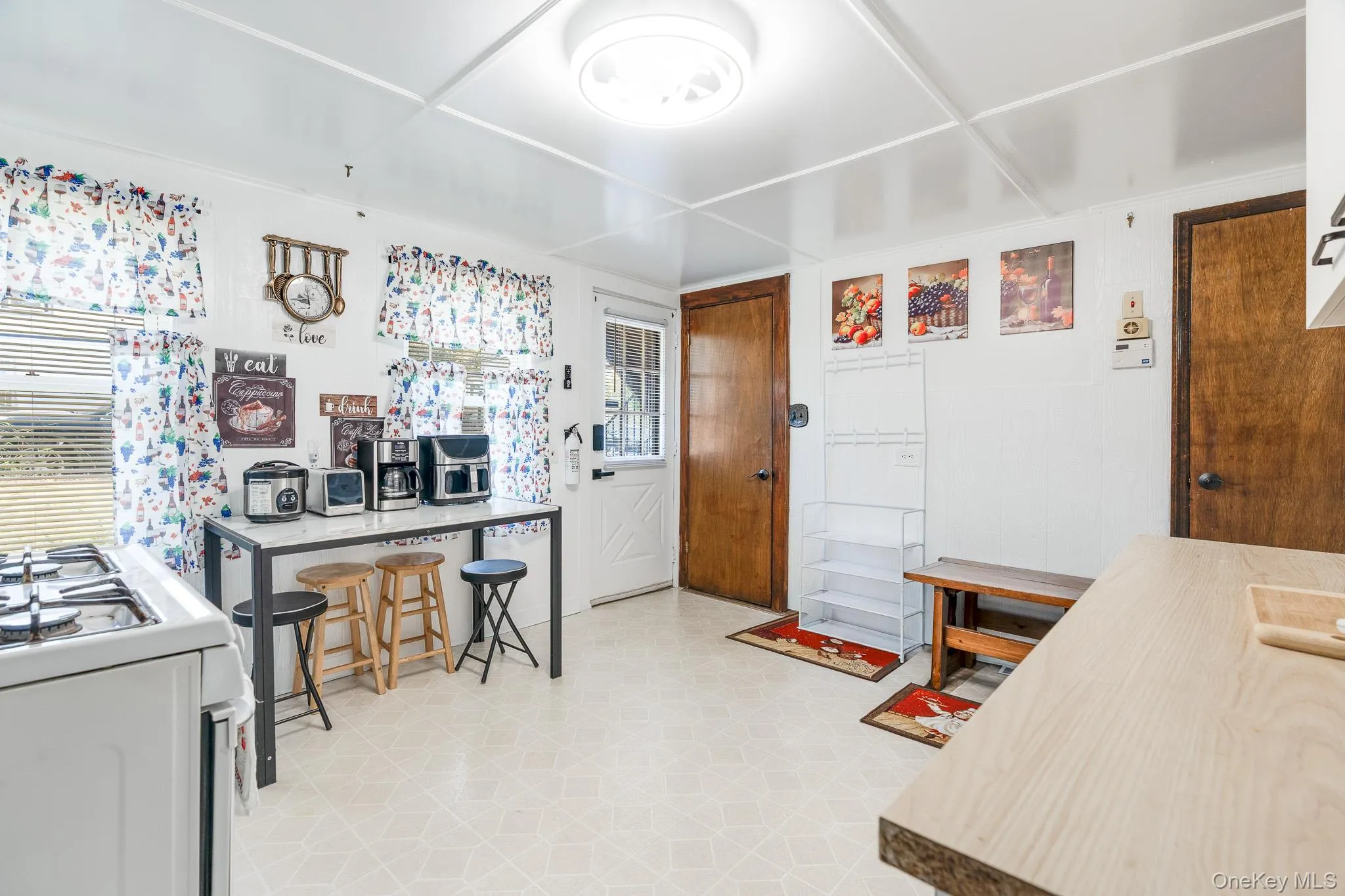 Kitchen with white gas stove, light floors, a kitchen breakfast bar, and wood counters Kitchen with white gas stove, light floors, a kitchen breakfast bar, and wood counters