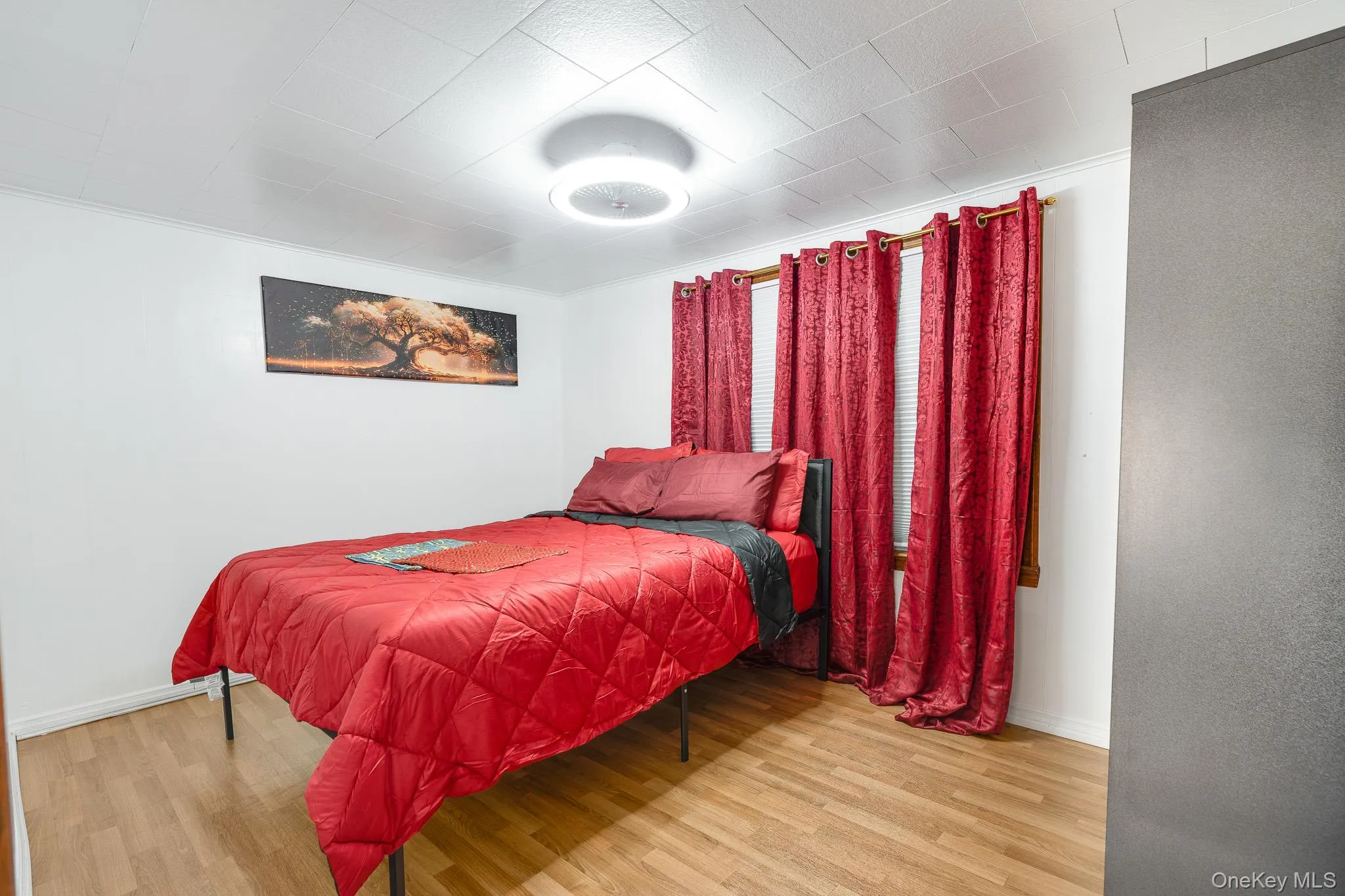 Bedroom featuring wood finished floors and crown molding Bedroom featuring wood finished floors and crown molding