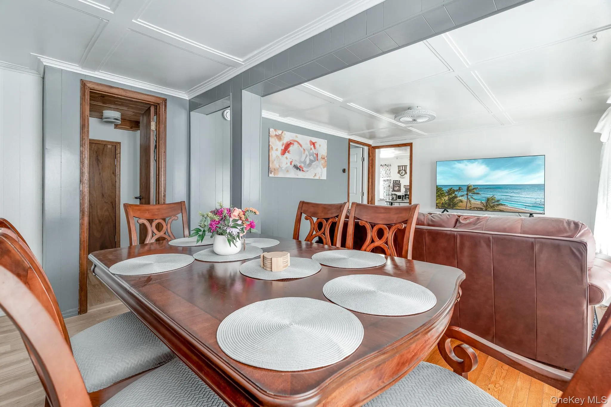 Dining space with wood finished floors and coffered ceiling Dining space with wood finished floors and coffered ceiling