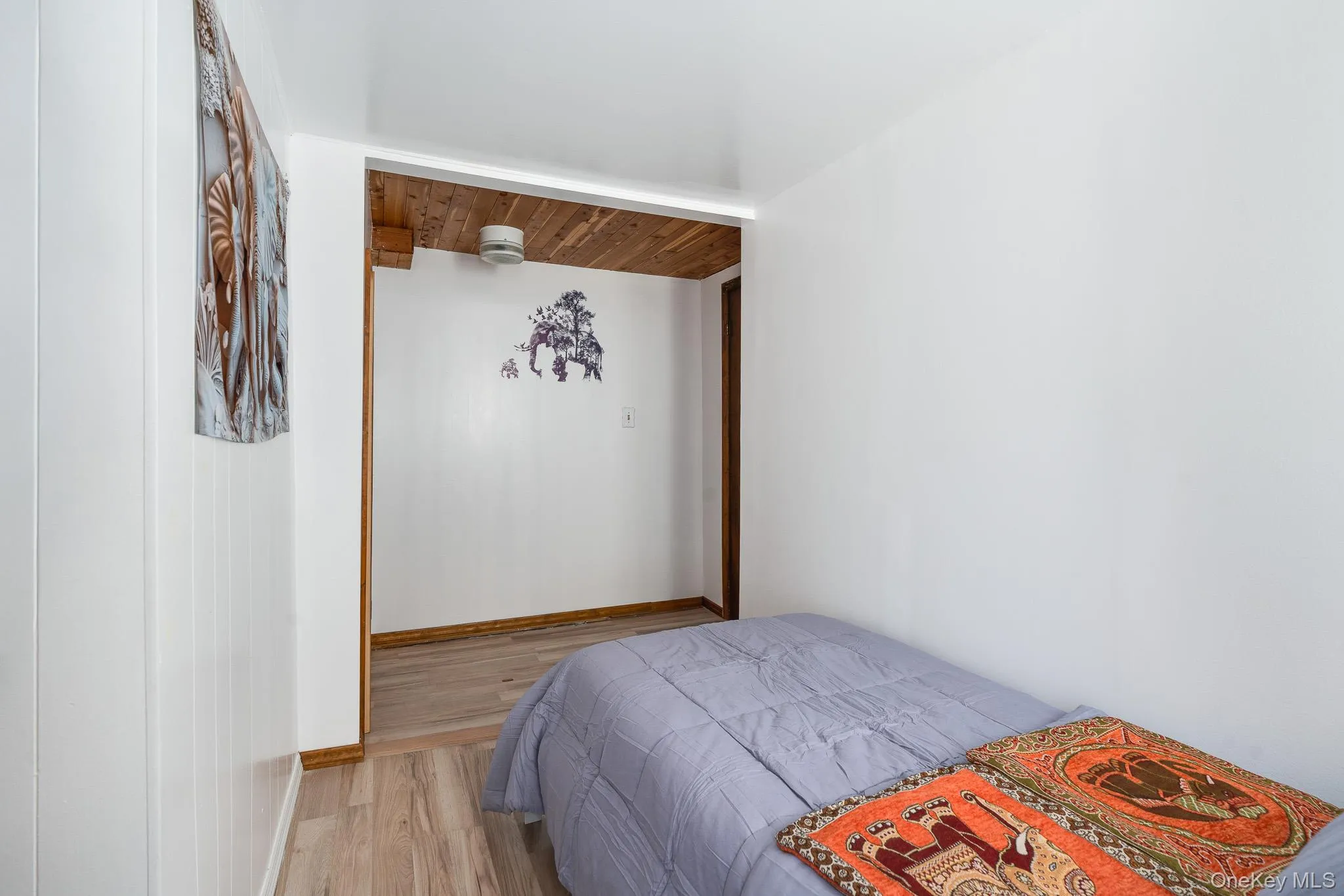 Bedroom featuring light wood-type flooring and wood ceiling Bedroom featuring light wood-type flooring and wood ceiling
