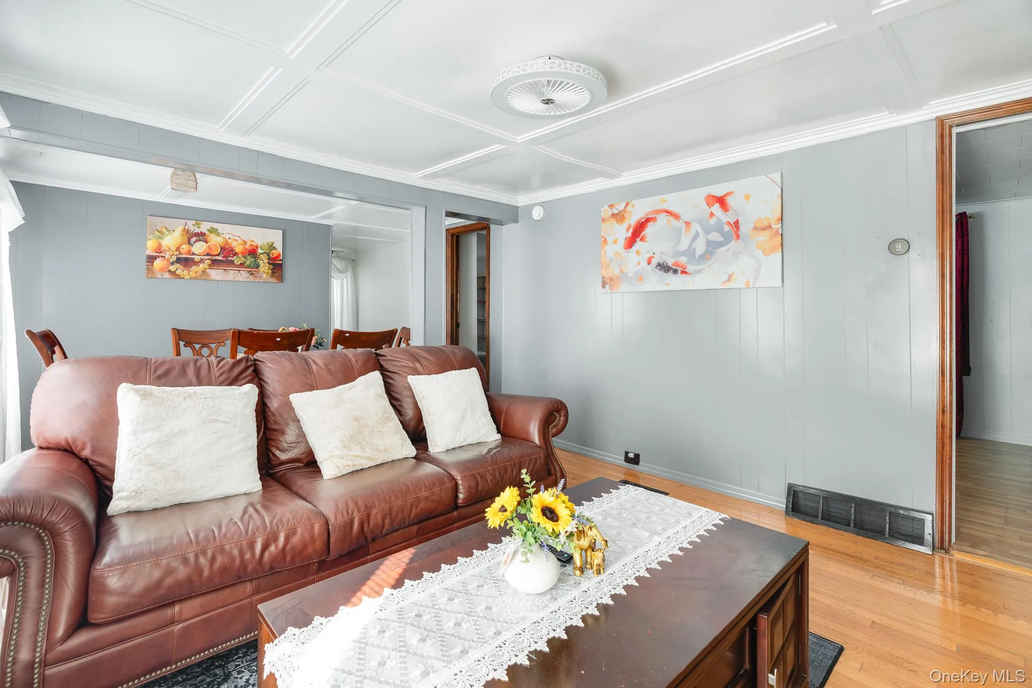 Living room featuring wood finished floors, wooden walls, and coffered ceiling Living room featuring wood finished floors, wooden walls, and coffered ceiling